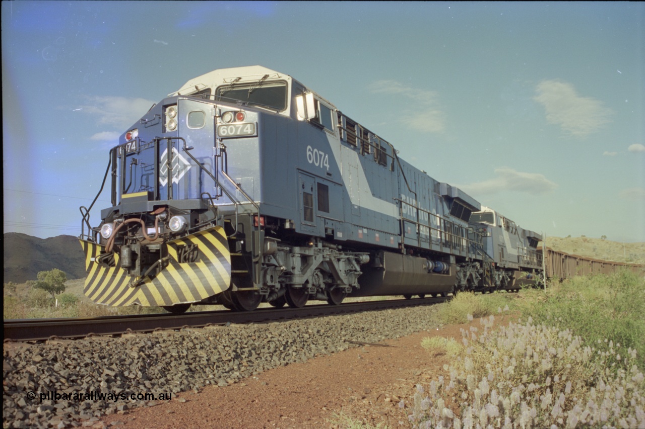 221-34
Yandi One mine loadout balloon loop, near new General Electric AC6000 unit 6074 serial 51066 leads sister unit 6071 serial 51063 at the Y312.1 km crossing while controlling a train being loaded.
Keywords: 6074;GE;AC6000;51066;