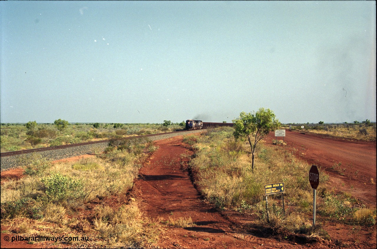 222-01
At the 105.7 km grade crossing near Gillam Siding, a loaded Yandi train approaches behind two General Electric AC6000 units built by GE at their Erie plant. This road was also the original road into Lynas Find Gold Project, back in the day. [url=https://goo.gl/maps/7emwhQdnBN32]GeoData[/url].
