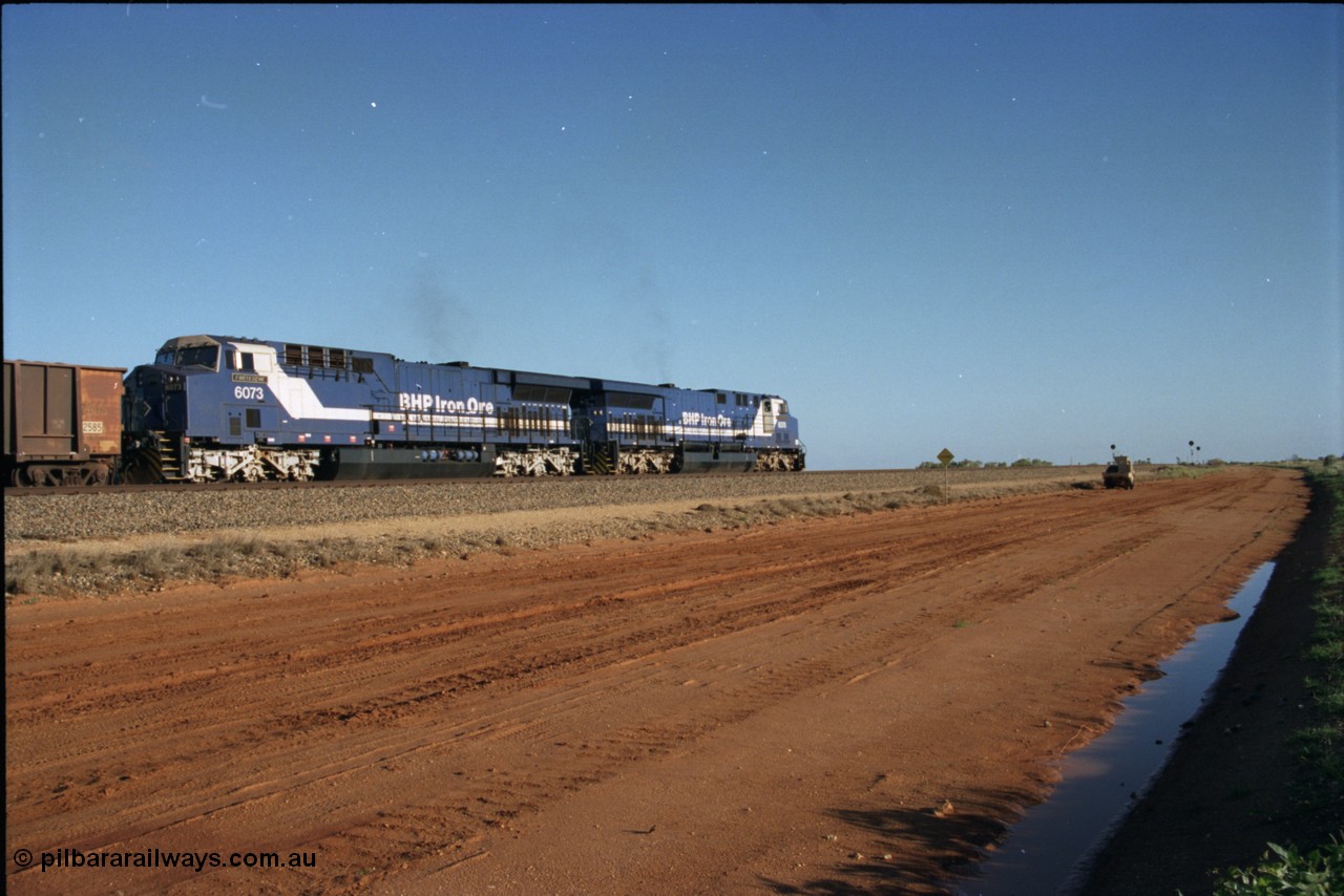 224-20
Bing siding, the afternoon empty to Yandi was a staple of the AC6000 units when delivered, operating the train as a pair, 112 waggons, AC6000 and 112 waggons. 6076 'Mt Goldsworthy' serial 51068 a General Electric AC6000 built by GE at Erie awaits the road to depart south with sister unit 6073. [url=https://goo.gl/maps/KQrczNpVhAH2]GeoData[/url].
Keywords: 6073;GE;AC6000;51065;