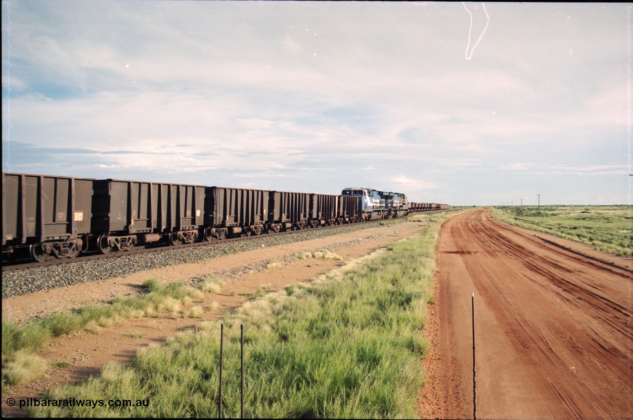 225-07
Bing siding, the afternoon departure for Yandi mine heads south past the ballast consist, behind the standard double General Electric AC6000 units with GE Erie built 6075 serial 51067 second unit to lead sister unit 6074 with another AC6000 unit mid-train. This was before the units were named. [url=https://goo.gl/maps/r3bVfZz8aJS2]GeoData[/url].
