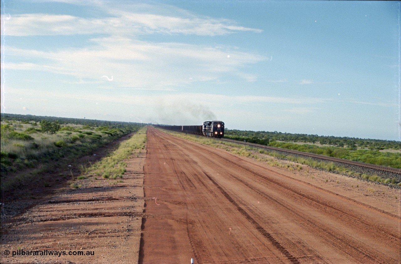 225-15
At the 24.1 km grade crossing on the BHP Newman line, the afternoon departure for Yandi mine heads south behind the standard double General Electric AC6000 units with another AC6000 unit mid-train. [url=https://goo.gl/maps/qGkyfiuy6212]GeoData[/url].
