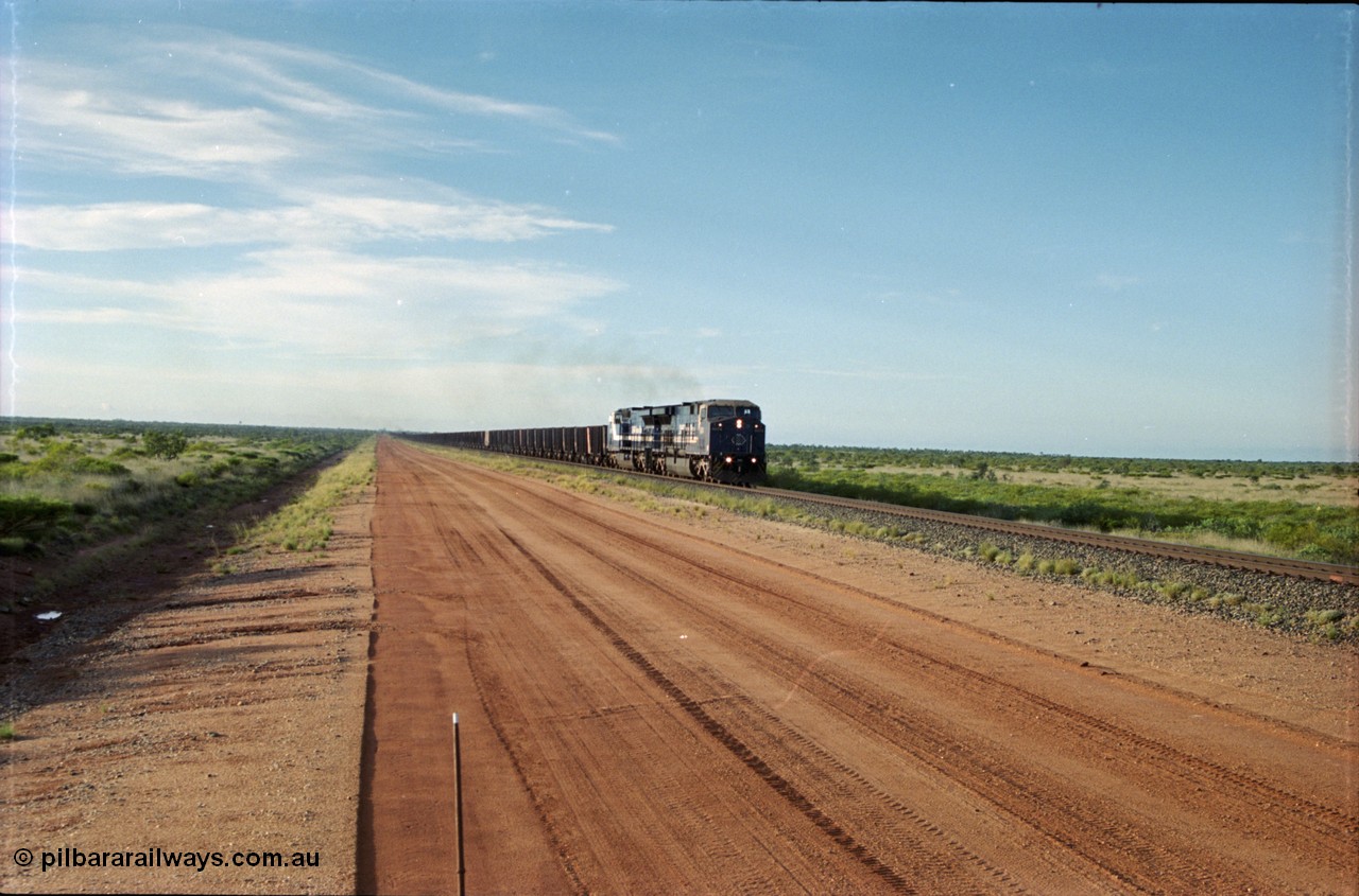 225-17
At the 24.1 km grade crossing on the BHP Newman line, the afternoon departure for Yandi mine heads south behind the standard double General Electric AC6000 units with GE Erie built 6074 serial 51066 leading sister unit 6075 with another AC6000 unit mid-train. This was before the units were named. [url=https://goo.gl/maps/qGkyfiuy6212]GeoData[/url].
Keywords: 6074;GE;AC6000;51066;