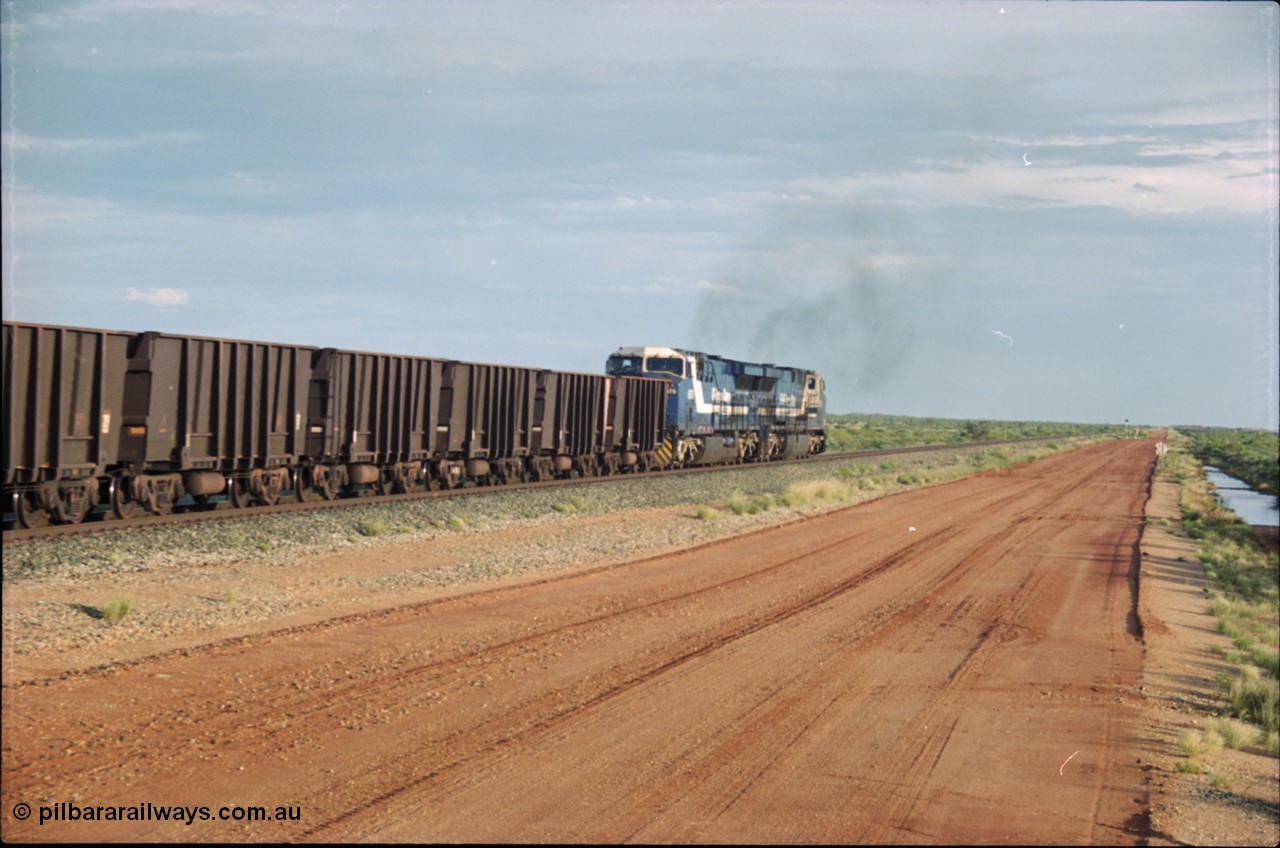 225-22
At the 24.1 km grade crossing on the BHP Newman line, the afternoon departure for Yandi mine heads south behind the standard double General Electric AC6000 units with GE Erie built 6075 serial 51067 second unit to lead sister unit 6074 with another AC6000 unit mid-train. This was before the units were named. [url=https://goo.gl/maps/qGkyfiuy6212]GeoData[/url].
