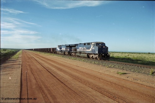 225-19
At the 24.1 km grade crossing on the BHP Newman line, the afternoon departure for Yandi mine heads south behind the standard double General Electric AC6000 units with GE Erie built 6074 serial 51066 leading sister unit 6075 with another AC6000 unit mid-train. This was before the units were named. [url=https://goo.gl/maps/qGkyfiuy6212]GeoData[/url].
Keywords: 6074;GE;AC6000CW;51066;