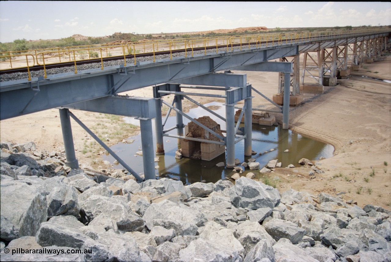 226-04
Yule River bridge showing new piles and deck to replace flood damaged piles after a cyclone that closed the line for two weeks in the late 1990s. [url=https://goo.gl/maps/G67Mat23u4P2]GeoData[/url].
