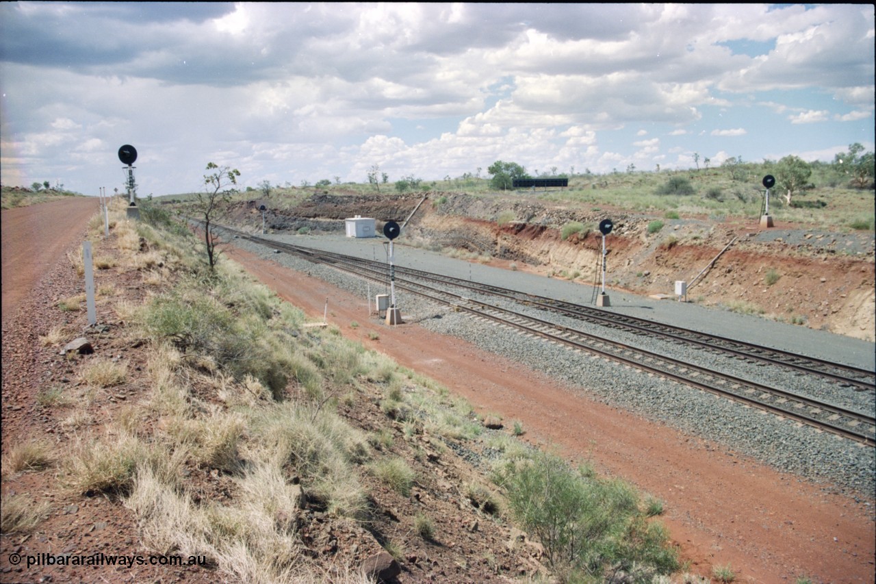 226-18
Shaw North, 216.5 km, expanded view showing departure signals from left to right, SWN 4R repeater for SWN 4, SWN 4 for the mainline and SWN 6 for the loop, then SWN 6R on the far right. Loaded trains are about to descend the steep 1.5 percent decent to Garden Siding from this location. The interlocking room with solar array mounted above the cutting in the background with the arrival signal also visible. The repeaters are due to the 700 metre radius curve north bound trains round to approach this location. [url=https://goo.gl/maps/emPzCHvnzAJ2]GeoData[/url].
