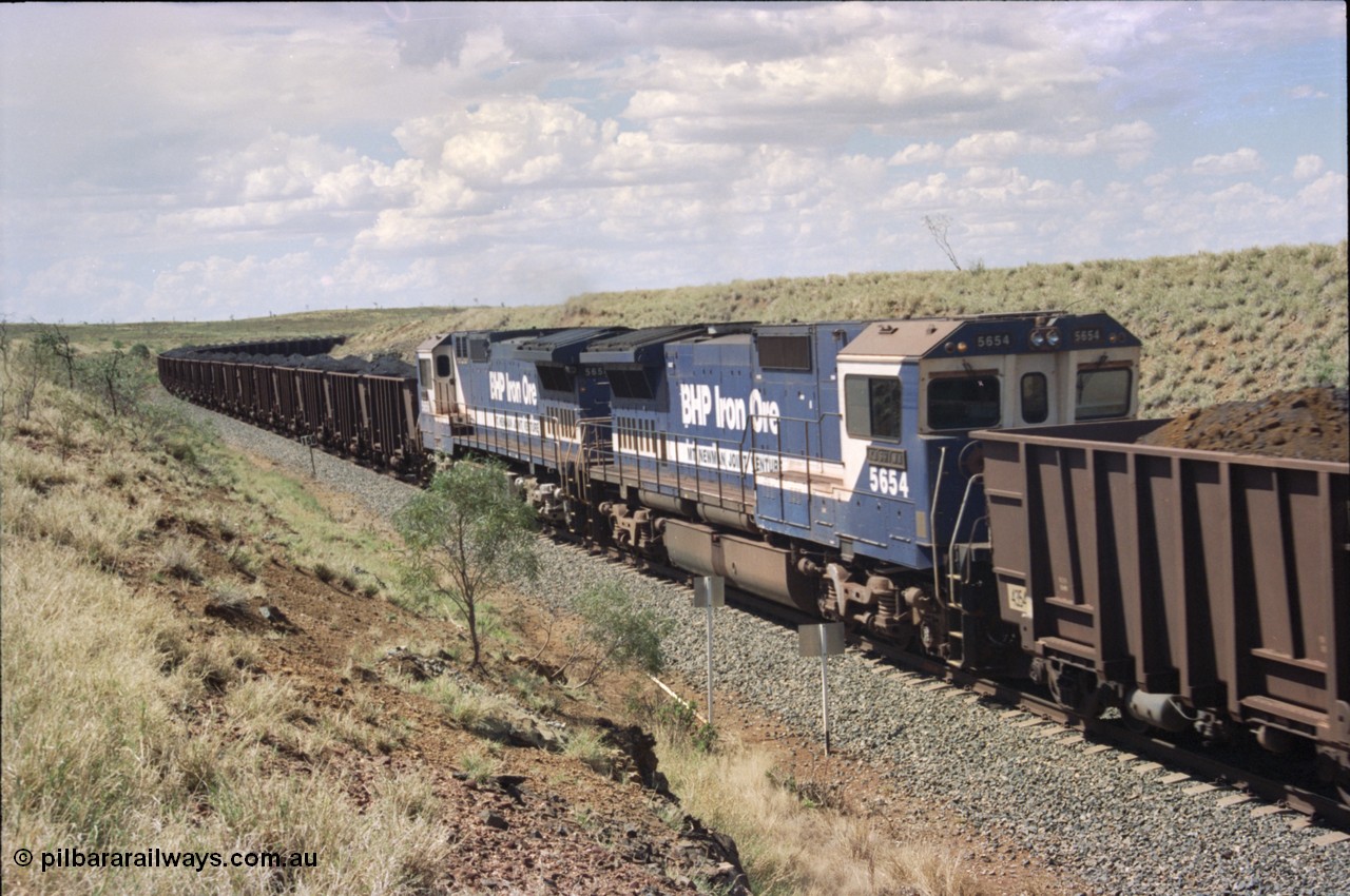 226-36
Shaw siding 219 km, 5654 'Kashima' serial 8412-11 / 93-145 is the trail or slave remote on the mid-train pair of units, note the large flat fuel tank indicating this unit was a Comeng NSW built ALCo before rebuild. [url=https://goo.gl/maps/JLjSYskHScU2]GeoData[/url].
Keywords: 5654;Goninan;GE;CM40-8M;8412-11/93-145;rebuild;Comeng-NSW;ALCo;M636C;5493;C6084-9;