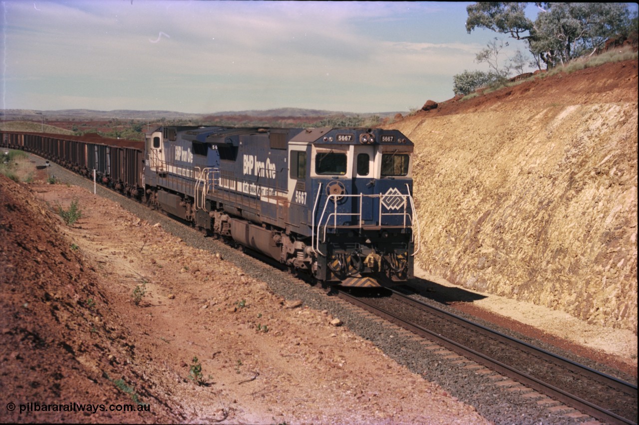 228-05
Yandi One, a loaded train creeps towards the Y308.1 km grade crossing while loading a train at 0.9 km/h. Goninan GE CM40-8MEFI rebuild unit 5667 'Redcar' serial 8412-12/94-158 leads an unidentified CM40-8 new build unit, either 5646 or 5647.
Keywords: 5667;Goninan;GE;CM40-8MEFI;8412-12/94-158;rebuild;Comeng-NSW;ALCo;M636C;5485;C6084-1;