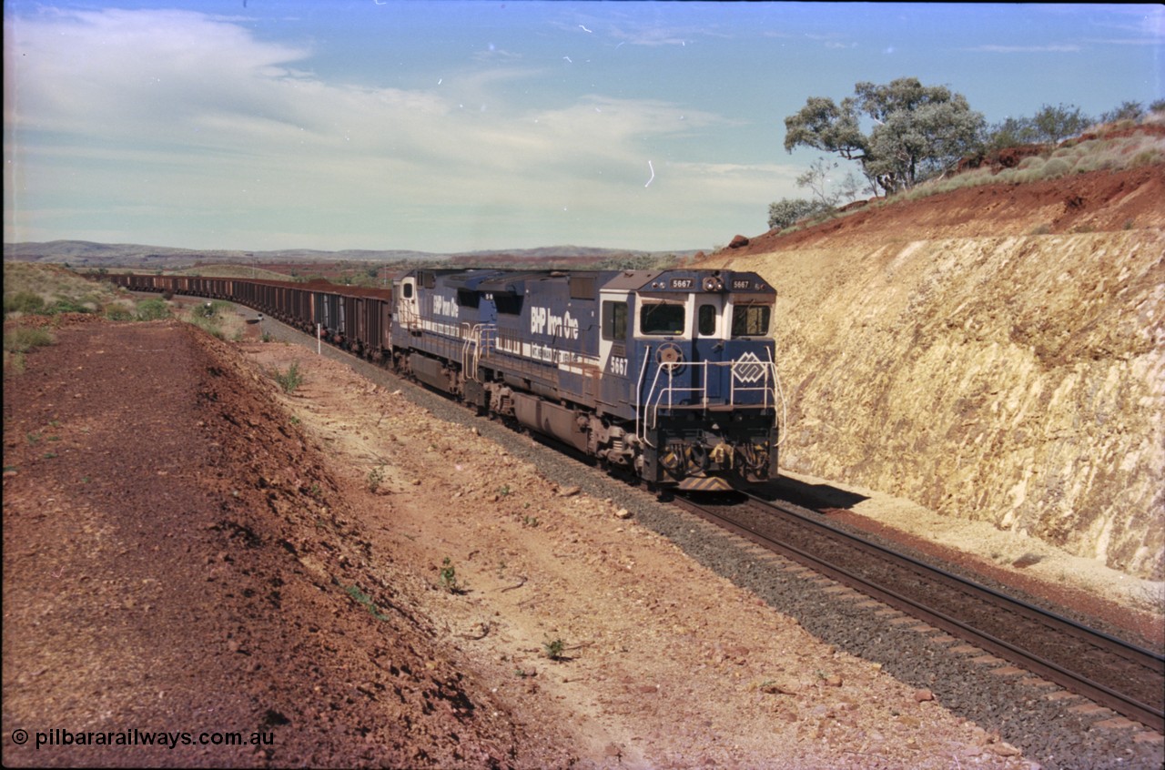 228-06
Yandi One, a loaded train creeps towards the Y308.1 km grade crossing while loading a train at 0.9 km/h. Goninan GE CM40-8MEFI rebuild unit 5667 'Redcar' serial 8412-12/94-158 leads an unidentified CM40-8 new build unit, either 5646 or 5647.
Keywords: 5667;Goninan;GE;CM40-8MEFI;8412-12/94-158;rebuild;Comeng-NSW;ALCo;M636C;5485;C6084-1;