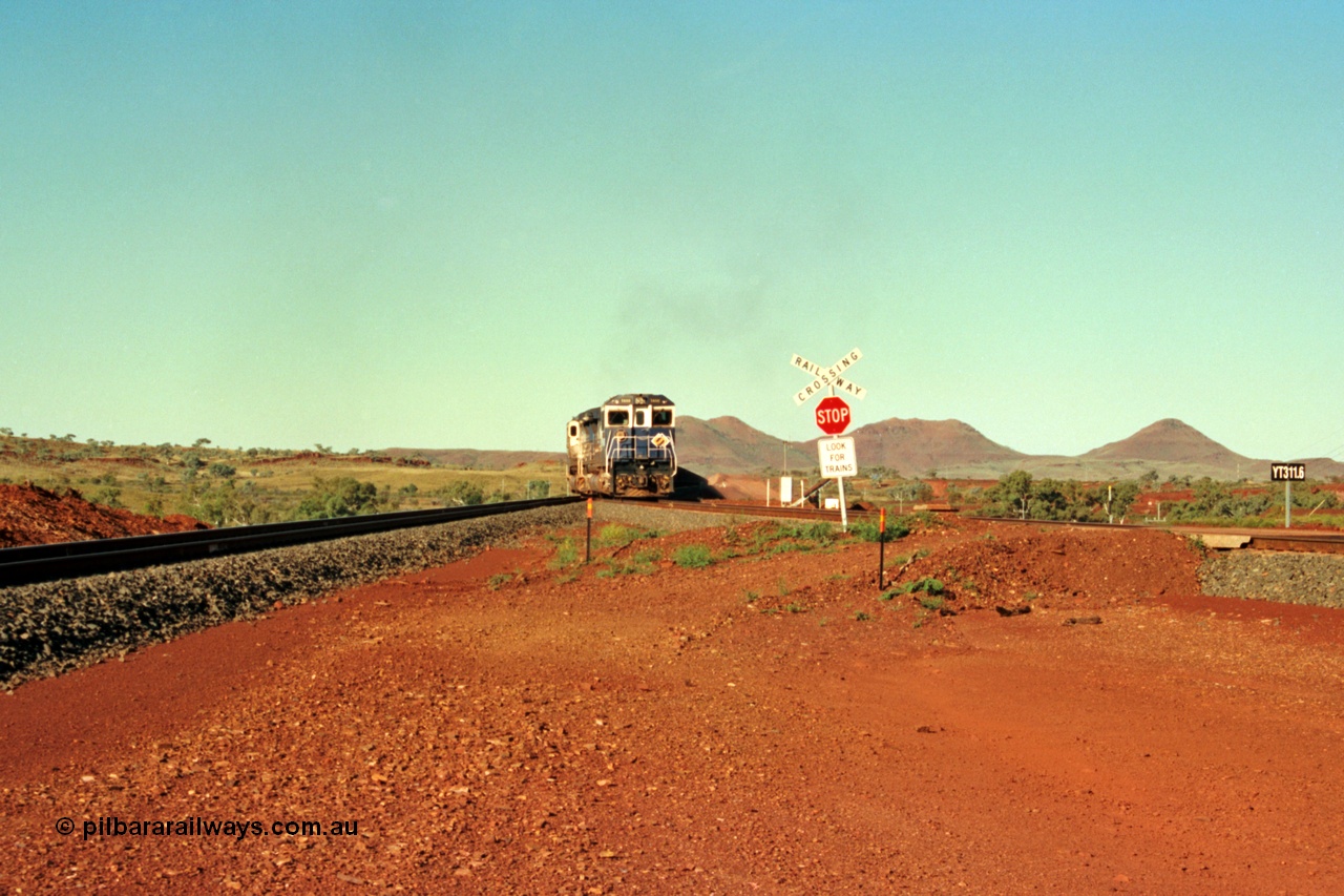 229-01
Yandi Two balloon switch looking east with the Three Sisters forming the background. Empty BHP train heading for the balloon loop for loading, grade crossing is the YT 311.5 km. [url=https://goo.gl/maps/DcycDGojcBt]GeoData[/url].
