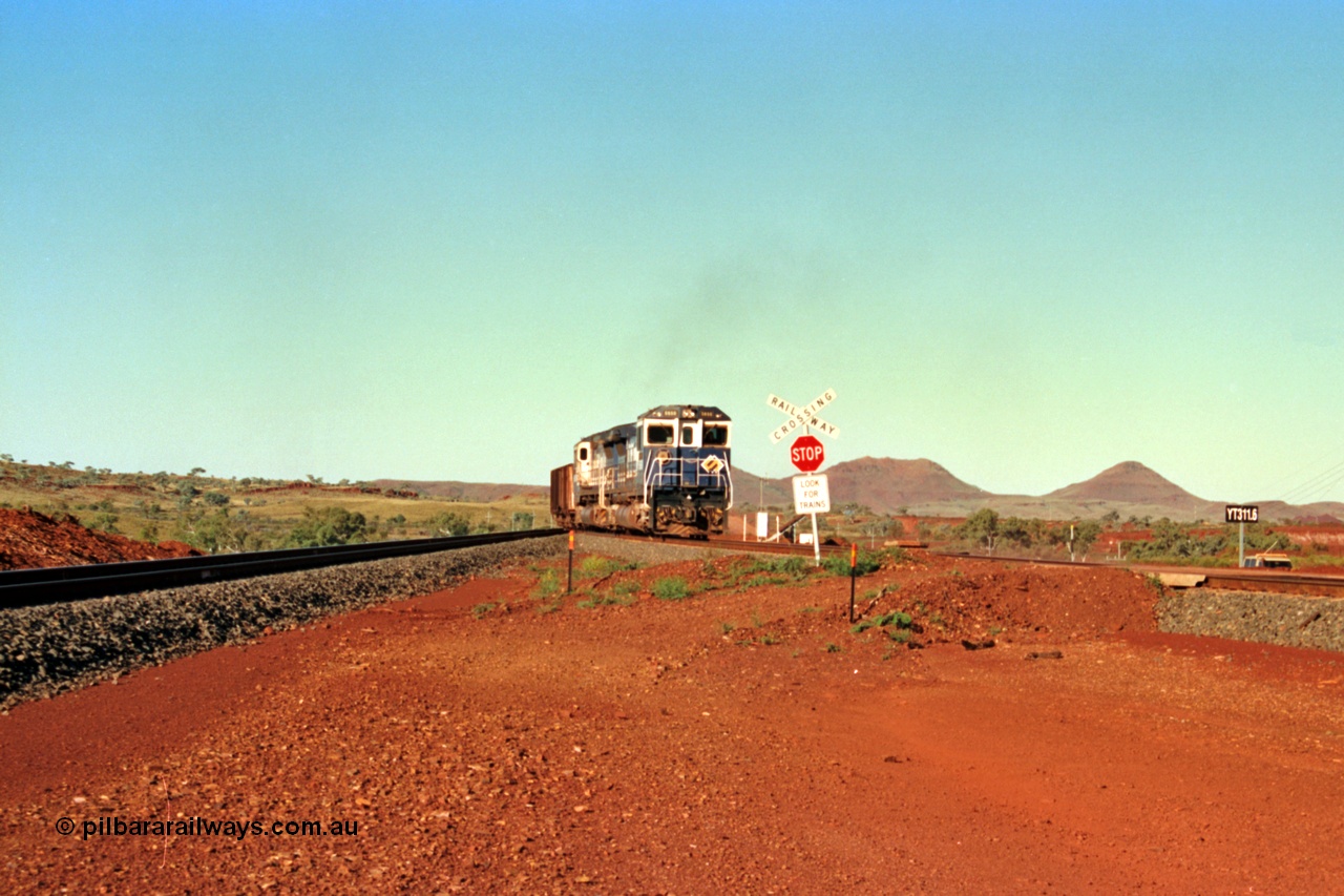 229-02
Yandi Two balloon switch looking east with the Three Sisters forming the background. Empty BHP train heading for the balloon loop for loading, grade crossing is the YT 311.5 km. [url=https://goo.gl/maps/DcycDGojcBt]GeoData[/url].
