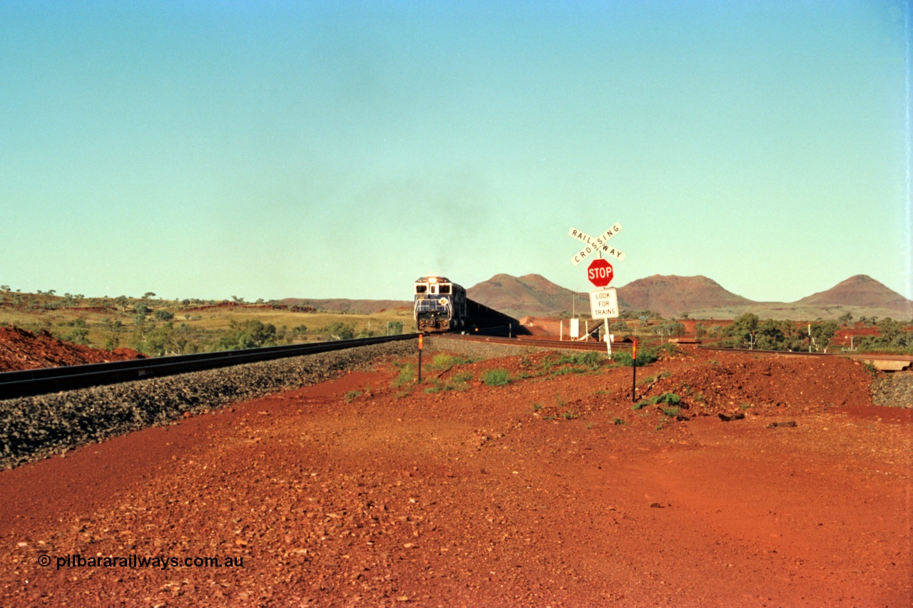 229-0A
Yandi Two balloon switch looking east with the Three Sisters forming the background. Empty BHP train heading for the balloon loop for loading, grade crossing is the YT 311.5 km. [url=https://goo.gl/maps/DcycDGojcBt]GeoData[/url].
