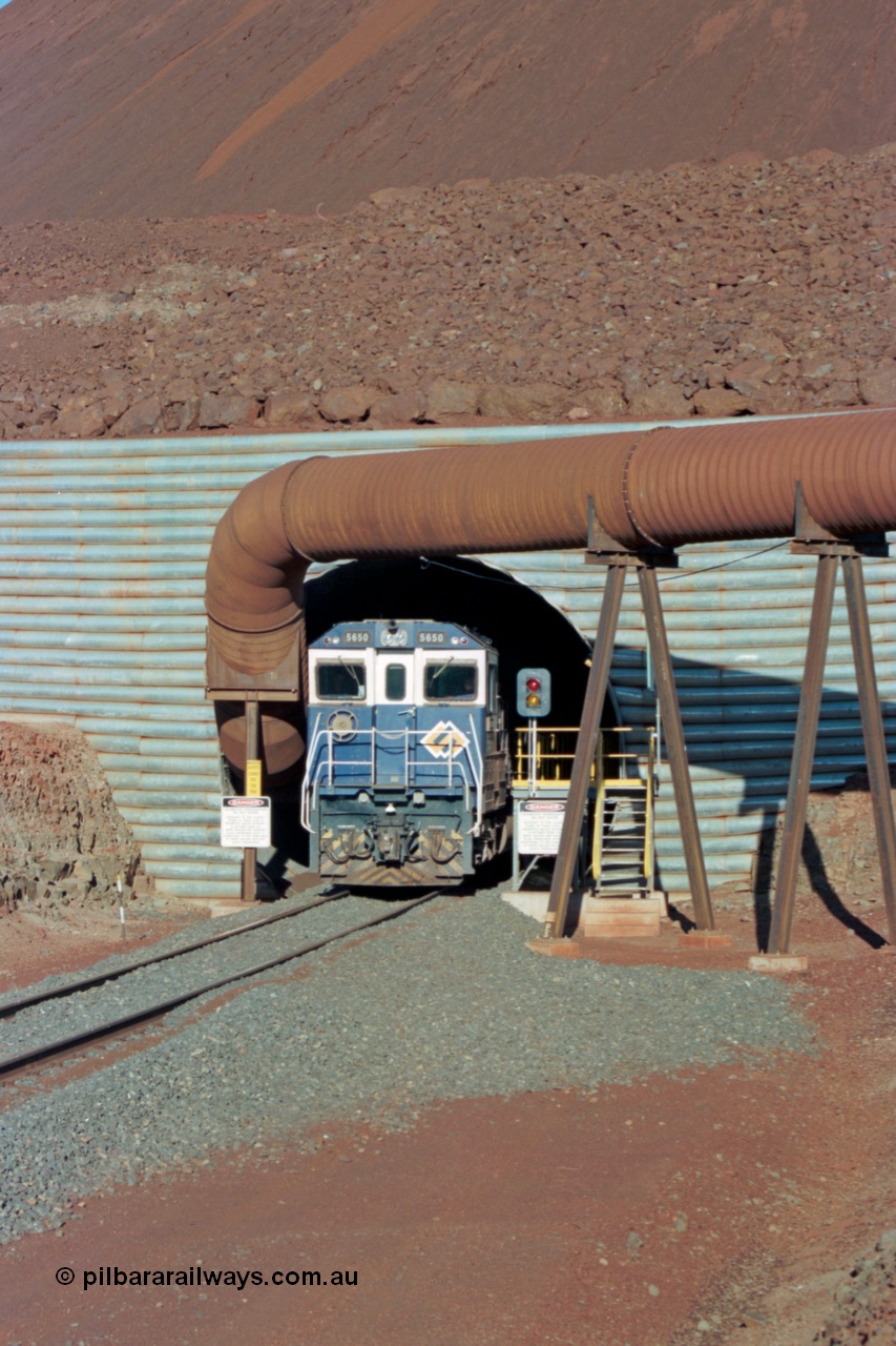 229-15
Yandi Two loadout, looking at the exit portal of the tunnel as Goninan rebuild CM40-8M GE unit 5650 'Yawata' serial 8412-07 / 93-141 drags a loading through at 1.2 km/h, the massive pile of ore is gravity fed into the waggons via two sets of hydraulic chutes, the red and amber lights control access through the tunnel and the steel pipe is for dust extraction. [url=https://goo.gl/maps/jmtnauf76Zq]GeoData[/url].
Keywords: 5650;Goninan;GE;CM40-8M;8412-07/93-141;rebuild;AE-Goodwin;ALCo;M636C;5481;G6061-2;