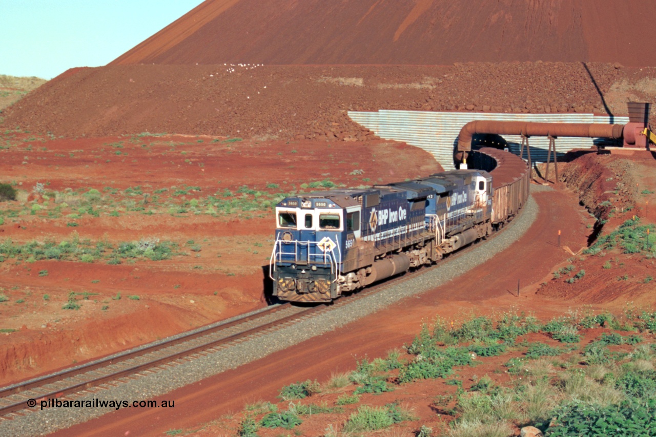 229-25
Yandi Two loadout exit side, Goninan rebuild CM40-8M GE units 5650 'Yawata' serial 8412-07 / 93-141 and sister unit 5642 drag a loading train at 1.2 km/h, both units carry the BHP Iron Ore teal and marigold livery for the logo. [url=https://goo.gl/maps/KQ3dQNrTwd42]GeoData[/url].
Keywords: 5650;Goninan;GE;CM40-8M;8412-07/93-141;rebuild;AE-Goodwin;ALCo;M636C;5481;G6061-2;