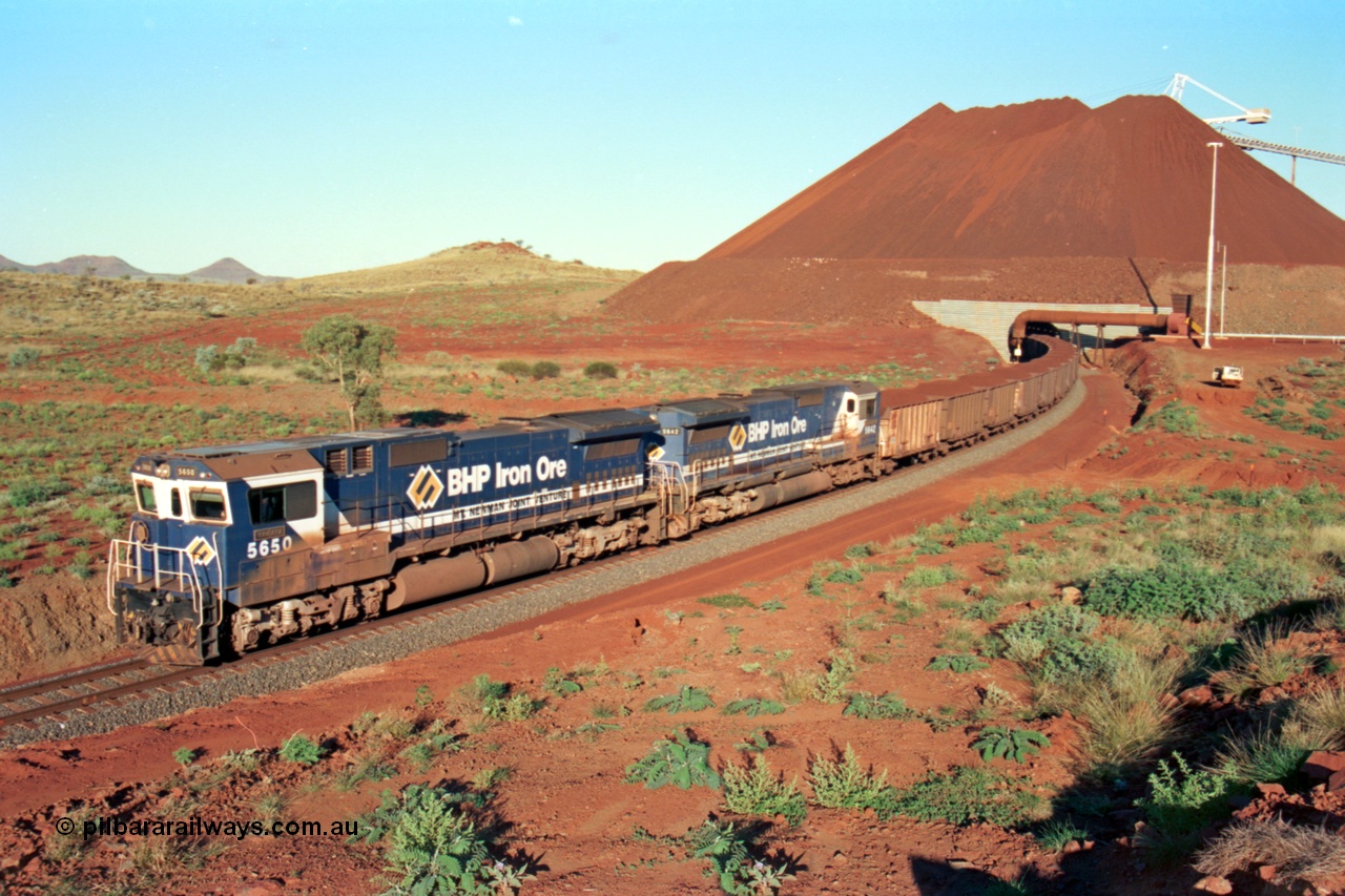 229-28
Yandi Two loadout exit side, as Goninan rebuild CM40-8M GE unit 5650 'Yawata' serial 8412-07 / 93-141 with sister unit 5642 drag a loading train at 1.2 km/h, the massive pile of ore is gravity fed into the waggons via two sets of hydraulic chutes, the original pedestal radial stacker is visible above the ore along with the extraction fan. [url=https://goo.gl/maps/KQ3dQNrTwd42]GeoData[/url].
Keywords: 5650;Goninan;GE;CM40-8M;8412-07/93-141;rebuild;AE-Goodwin;ALCo;M636C;5481;G6061-2;