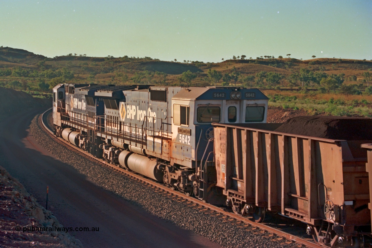 229-32
Yandi Two loadout exit side, as second unit 5642 'Wallareenya' serial 8281-07 / 92-131 a Goninan rebuild CM40-8M GE unit trails sister unit 5650 drag a loading train at 1.2 km/h around the loadout balloon, the waggon behind 5642 is an original Oroville waggon. [url=https://goo.gl/maps/KQ3dQNrTwd42]GeoData[/url].
Keywords: 5642;Goninan;GE;CM40-8M;8281-07/92-131;rebuild;AE-Goodwin;ALCo;C636;5467;G6041-3;