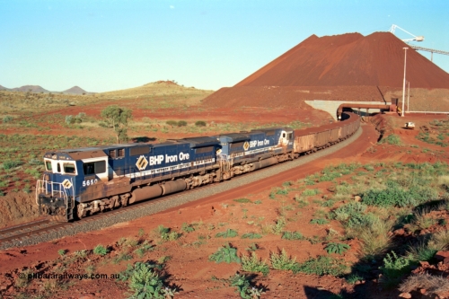 229-28
Yandi Two loadout exit side, as Goninan rebuild CM40-8M GE unit 5650 'Yawata' serial 8412-07 / 93-141 with sister unit 5642 drag a loading train at 1.2 km/h, the massive pile of ore is gravity fed into the waggons via two sets of hydraulic chutes, the original pedestal radial stacker is visible above the ore along with the extraction fan. [url=https://goo.gl/maps/KQ3dQNrTwd42]GeoData[/url].
Keywords: 5650;Goninan;GE;CM40-8M;8412-07/93-141;rebuild;AE-Goodwin;ALCo;M636C;5481;G6061-2;