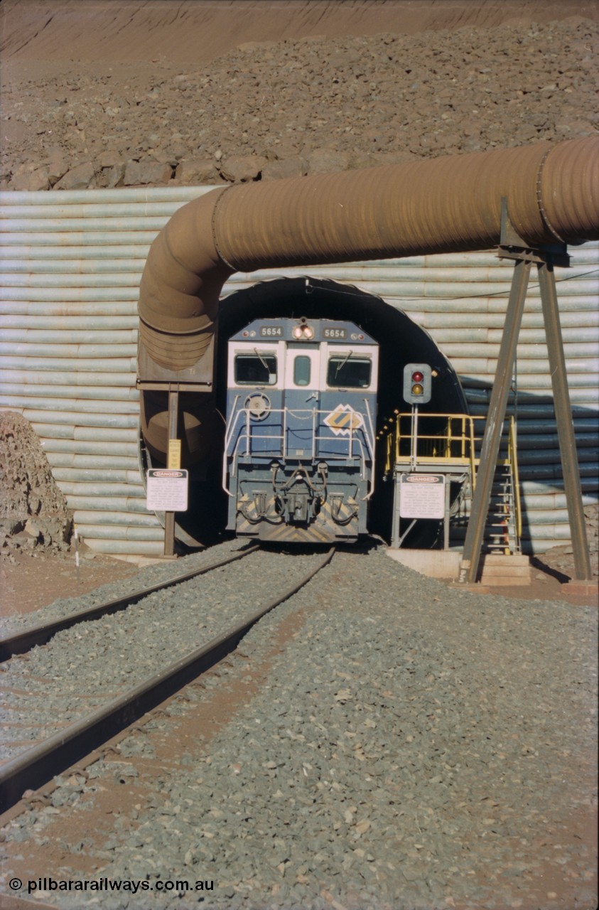 230-11
Yandi Two load-out tunnel exit side portal, Goninan rebuild GE CM40-8M model 5654 'Kashima' serial 8412-11/93-145 creeps out of the tunnel as its train is loaded at 1.2 km/h. The livery is the marigold version of the BHP Australia logo. Geodata [url=https://goo.gl/maps/h68ia1caJvL2] -22.718338, 119.039909 [/url].
Keywords: 5654;Goninan;GE;CM40-8M;8412-11/93-145;rebuild;Comeng-NSW;ALCo;M636C;5493;C6084-9;