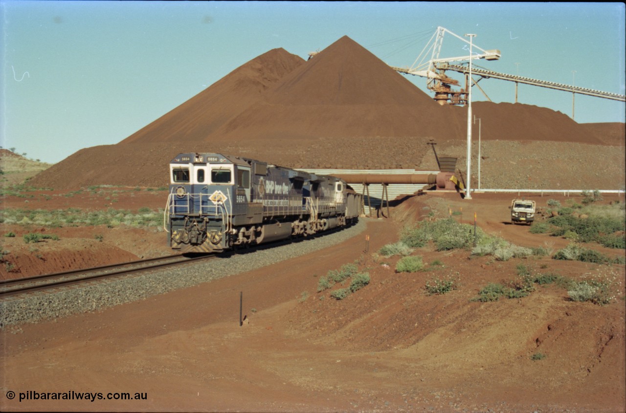 230-24
Yandi Two balloon loop, view of the stockpile area and pedestal stacker, train being loaded at 1.2 km/h behind two Goninan GE CM40-8M rebuilds from different ALCo builders. 5654 'Kashima' serial 8412-11/93-145 is from Comeng ALCo M636 unit 5493 while 5637 'De Grey' serial 8181-01/92-123 is from an AE Goodwin ALCo C636 unit 5456. Geodata [url=https://goo.gl/maps/h68ia1caJvL2] -22.718338, 119.039909 [/url].
Keywords: 5654;Goninan;GE;CM40-8M;8412-11/93-145;rebuild;Comeng-NSW;ALCo;M636C;5493;C6084-9;