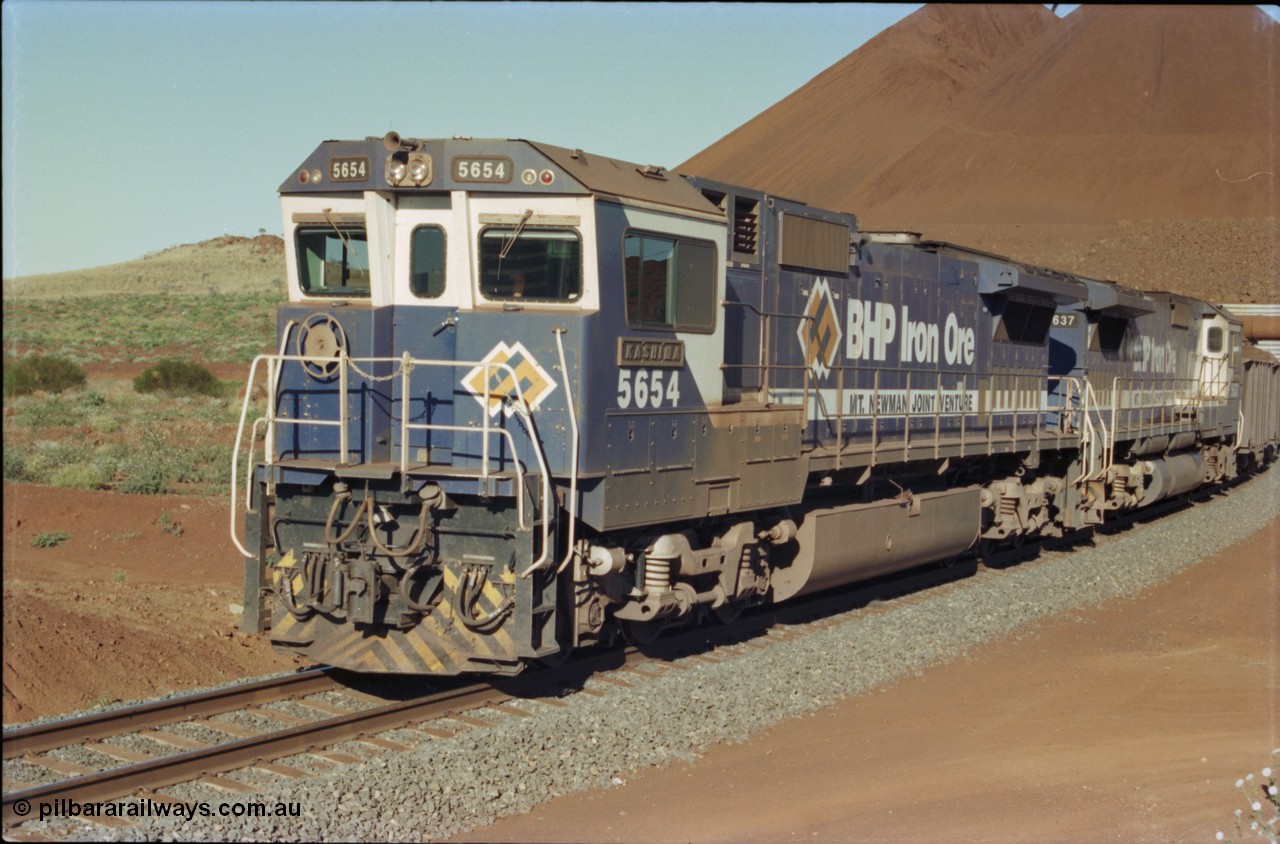 230-28
Yandi Two balloon loop, two Goninan GE CM40-8M rebuilds from different ALCo builders. 5654 'Kashima' serial 8412-11/93-145 is from Comeng ALCo M636 unit 5493 while 5637 'De Grey' serial 8181-01/92-123 is from an AE Goodwin ALCo C636 unit 5456. 5654 wears the marigold BHP logo while 5637 has the silver logo on one the ends. Geodata [url=https://goo.gl/maps/h68ia1caJvL2] -22.718338, 119.039909 [/url].
Keywords: 5654;Goninan;GE;CM40-8M;8412-11/93-145;rebuild;Comeng-NSW;ALCo;M636C;5493;C6084-9;