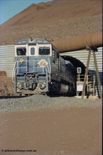 230-15
Yandi Two load-out tunnel exit side portal, Goninan rebuild GE CM40-8M model 5654 'Kashima' serial 8412-11/93-145 creeps out of the tunnel as its train is loaded at 1.2 km/h. The livery is the marigold version of the BHP Australia logo. Geodata [url=https://goo.gl/maps/h68ia1caJvL2] -22.718338, 119.039909 [/url].
Keywords: 5654;Goninan;GE;CM40-8M;8412-11/93-145;rebuild;Comeng-NSW;ALCo;M636C;5493;C6084-9;