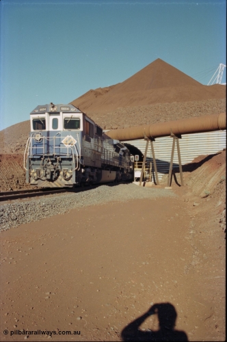 230-16
Yandi Two load-out tunnel exit side portal, Goninan rebuild GE CM40-8M model 5654 'Kashima' serial 8412-11/93-145 leads a loading train 1.2 km/h. The ore stockpile and pedestal stacker are visible. The livery is the marigold version of the BHP Australia logo. Geodata [url=https://goo.gl/maps/h68ia1caJvL2] -22.718338, 119.039909 [/url].
Keywords: 5654;Goninan;GE;CM40-8M;8412-11/93-145;rebuild;Comeng-NSW;ALCo;M636C;5493;C6084-9;