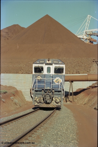 230-20
Yandi Two load-out tunnel exit side portal, Goninan rebuild GE CM40-8M model 5654 'Kashima' serial 8412-11/93-145 leads a loading train 1.2 km/h. The ore stockpile and pedestal stacker are visible. The livery is the marigold version of the BHP Australia logo. Geodata [url=https://goo.gl/maps/h68ia1caJvL2] -22.718338, 119.039909 [/url].
Keywords: 5654;Goninan;GE;CM40-8M;8412-11/93-145;rebuild;Comeng-NSW;ALCo;M636C;5493;C6084-9;