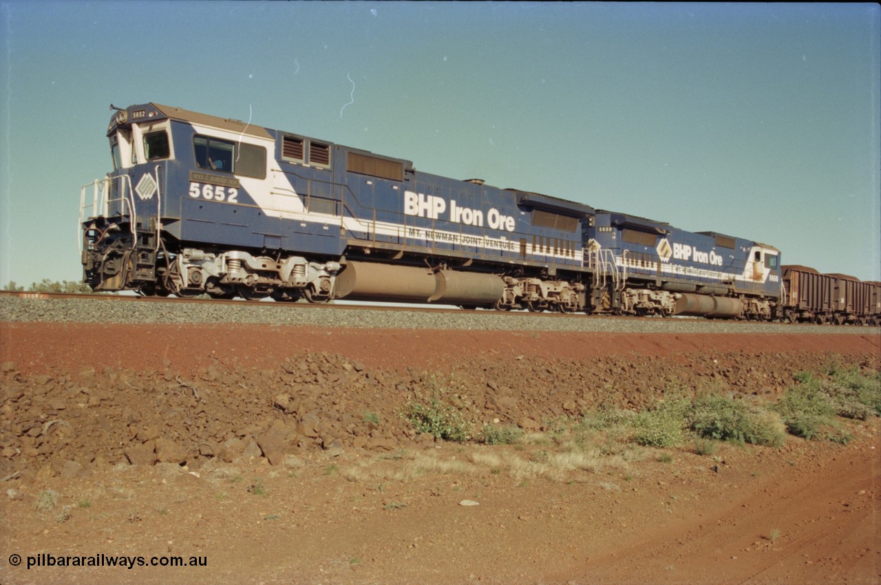 231-04
Yandi Two balloon loop, BHP Iron Ore 5652 'Villanueva' serial 8412-09 / 93-143 an Goninan WA rebuild CM40-8M GE unit loads a train at 1.2 km/h with second unit 5650 'Yawata' serial 8412-07 / 93-141, note the difference in the liveries, 50 is in the teal and marigold logo and logo on the hood while 52 has the silver logo on the front only and no logo on the hood. [url=https://goo.gl/maps/3vQHZqBXNa32]GeoData[/url].
Keywords: 5652;Goninan;GE;CM40-8M;8412-09/93-143;rebuild;AE-Goodwin;ALCo;M636C;5482;G6061-3;