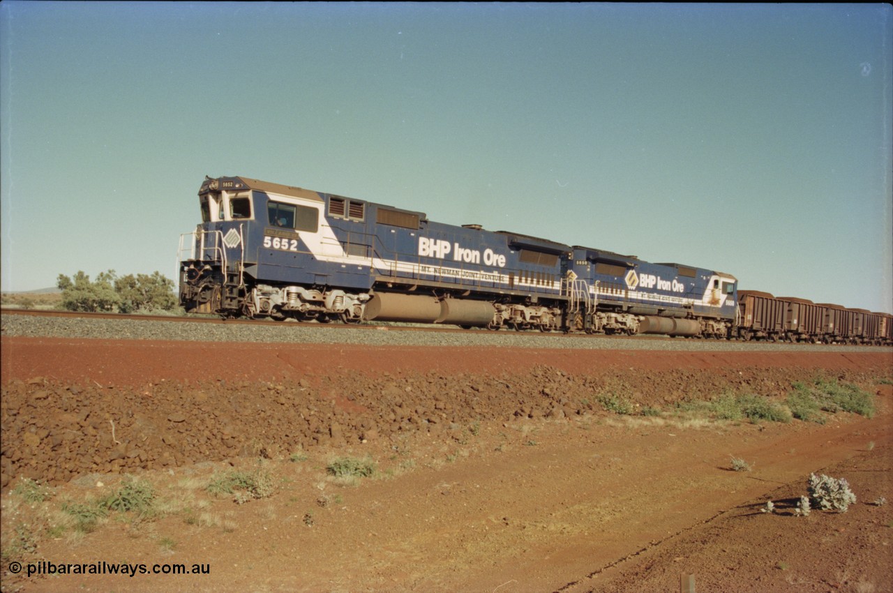 231-05
Yandi Two balloon loop, BHP Iron Ore 5652 'Villanueva' serial 8412-09 / 93-143 an Goninan WA rebuild CM40-8M GE unit loads a train at 1.2 km/h with second unit 5650 'Yawata' serial 8412-07 / 93-141, note the difference in the liveries, 50 is in the teal and marigold logo and logo on the hood while 52 has the silver logo on the front only and no logo on the hood. [url=https://goo.gl/maps/3vQHZqBXNa32]GeoData[/url].
Keywords: 5652;Goninan;GE;CM40-8M;8412-09/93-143;rebuild;AE-Goodwin;ALCo;M636C;5482;G6061-3;