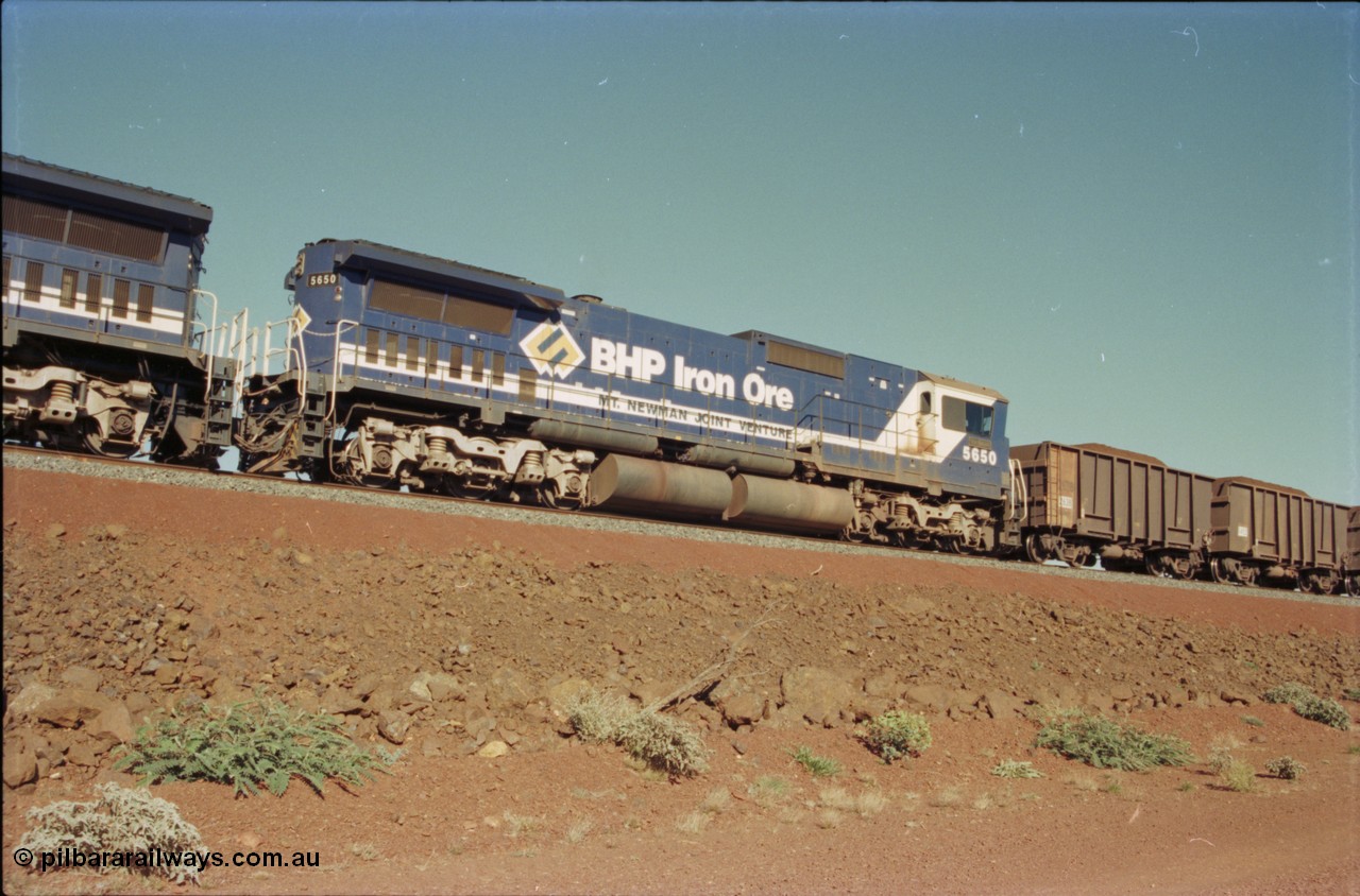 231-15
Yandi Two balloon loop, BHP Iron Ore 5650 'Yawata' serial 8412-09 / 93-141 an Goninan WA rebuild CM40-8M GE unit loads a train at 1.2 km/h as second unit, note the logos are the original teal and marigold and the round style fuel tanks tells us this units was rebuilt from an AE Goodwin built M636 ALCo. [url=https://goo.gl/maps/3vQHZqBXNa32]GeoData[/url].
Keywords: 5650;Goninan;GE;CM40-8M;8412-07/93-141;rebuild;AE-Goodwin;ALCo;M636C;5481;G6061-2;