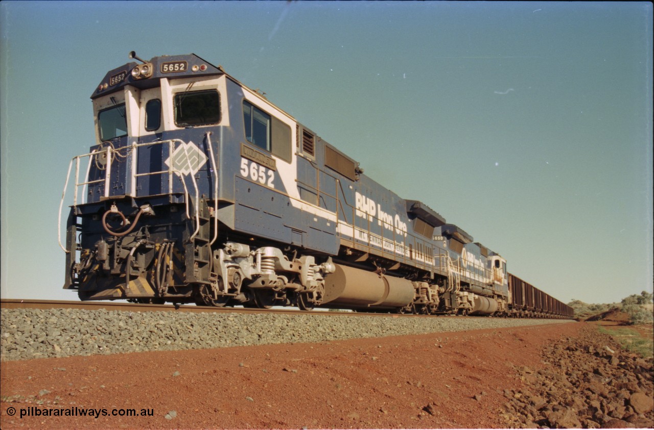 231-26
Yandi Two balloon loop, BHP Iron Ore 5652 'Villanueva' serial 8412-09 / 93-143 an Goninan WA rebuild CM40-8M GE unit loads a train at 1.2 km/h with second unit 5650. [url=https://goo.gl/maps/3vQHZqBXNa32]GeoData[/url].
Keywords: 5652;Goninan;GE;CM40-8M;8412-09/93-143;rebuild;AE-Goodwin;ALCo;M636C;5482;G6061-3;