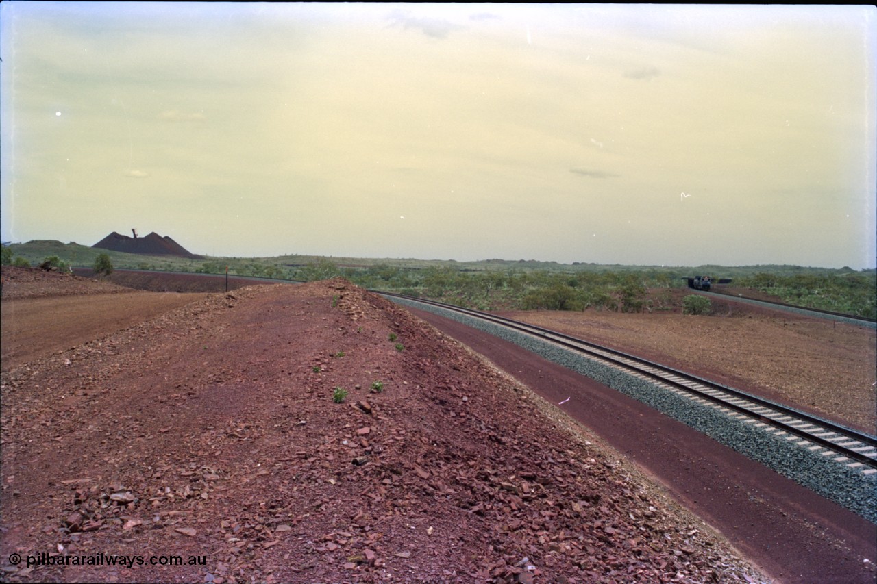 232-03
Yandi Two, view to the stockpile looking west from near the 311.6 km grade crossing. A train can be seen loading on the right. February 1997. [url=https://goo.gl/maps/3tst5WV949N2]GeoData[/url].
