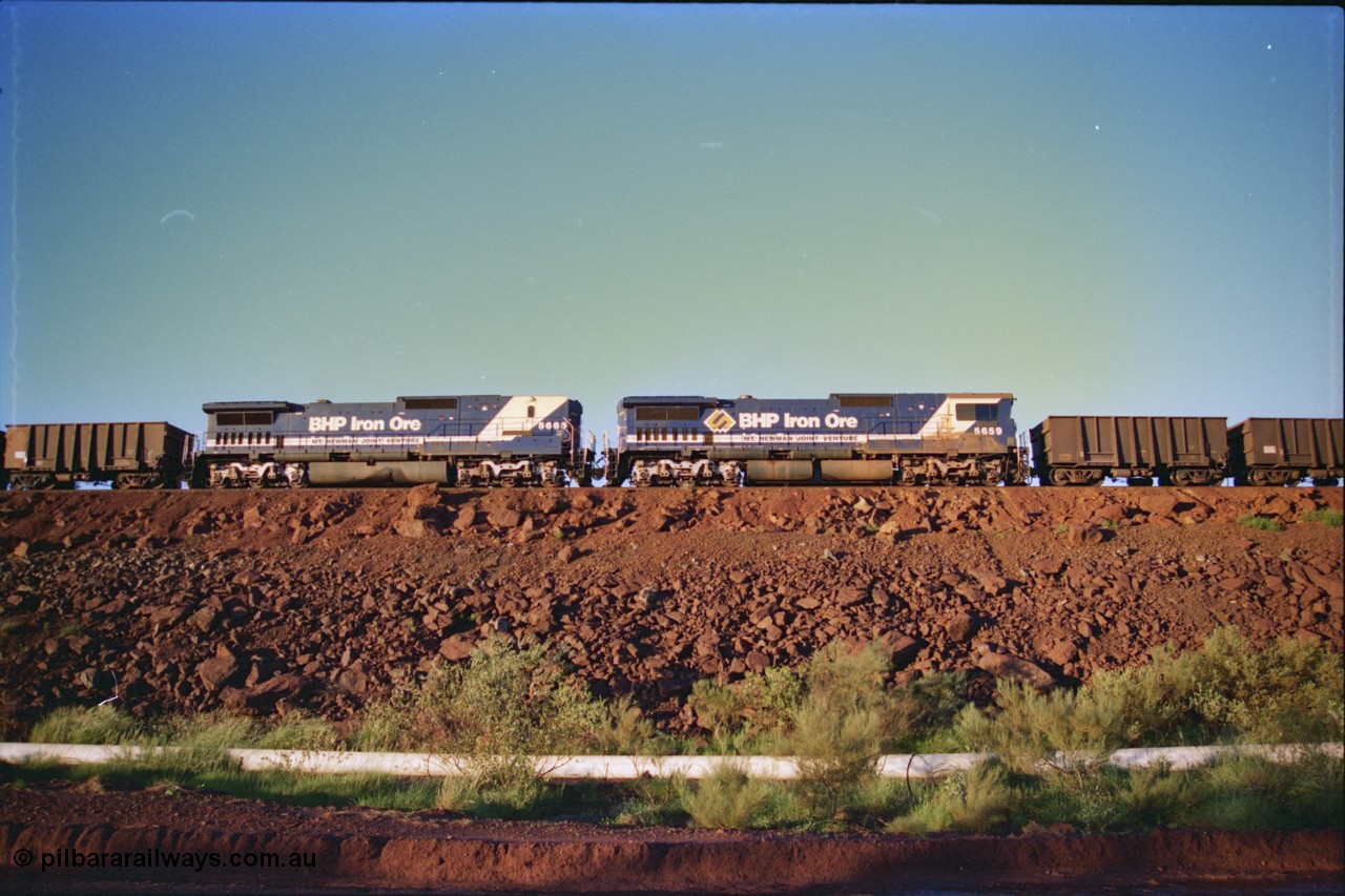 232-05
Yandi One balloon loop, mid-train remote units of train no. 1718 which is partway through loading, BHP Iron Ore unit 5659 'Kobe' serial 8412-04 / 94-150 leads cab-less unit 5665 'Rotterdam' serial 8412-10 / 94-156, both are Goninan rebuild CM40-8M GE units with 65 having an L on its' designation as cabless with LocoTrol. 3rd February 1997. [url=https://goo.gl/maps/JhTwdFuTRZo]GeoData[/url].
Keywords: 5659;Goninan;GE;CM40-8M;8412-04/94-150;rebuild;AE-Goodwin;ALCo;M636C;5483;G6061-4;