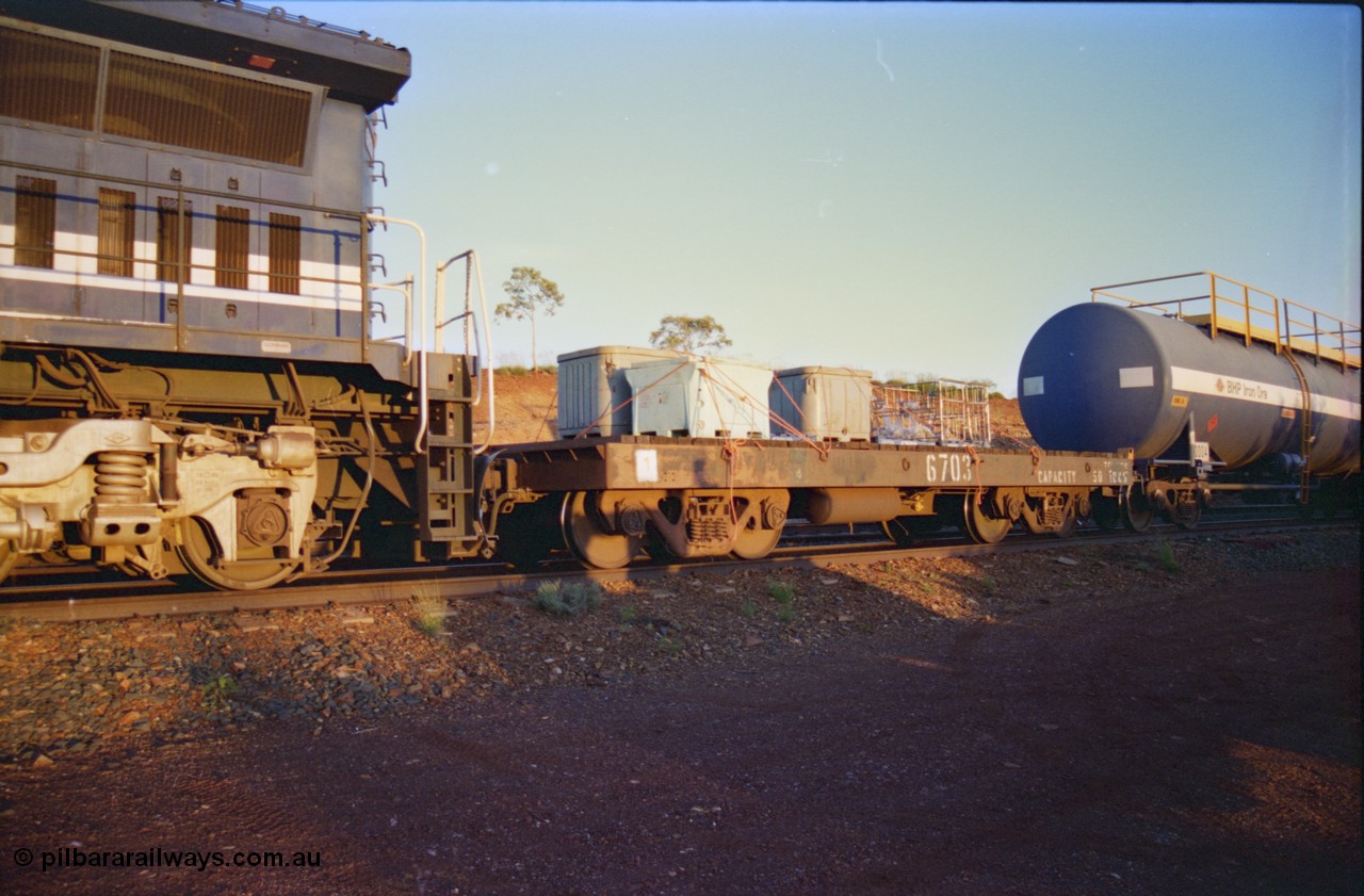 232-13
Yandi One backtrack, following a cyclone shutdown of the mainline and severe flooding around Yandi a 'mixed' freight train was operated to Yandi to deliver food, mail and diesel fuel to the mine and camp. Here BHP Iron Ore 50 ton waggon 6703, one of three 'special' waggons converted from Magor USA built ore waggons by the Mt Newman Workshops. February 1997. [url=https://goo.gl/maps/6c1WFqjYSg42]GeoData[/url].
Keywords: 6703;Mt-Newman-Mining-WS;Magor-USA;