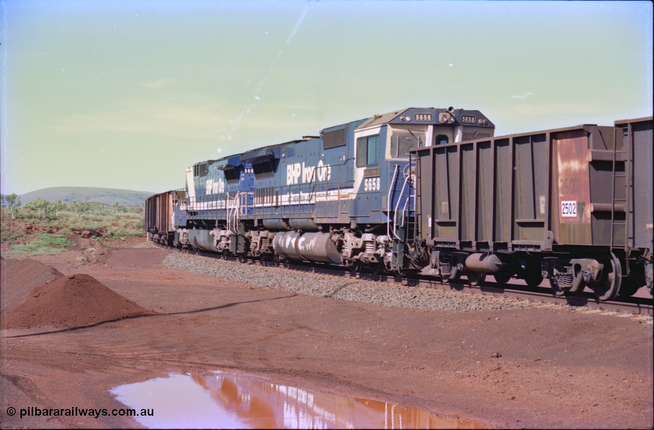 232-26
Yandi One balloon loop, as a train is being loaded the mid-train remotes approach, waggon 2502 is a standard Comeng WA build from the third batch of 180 waggons built in 1970. Goninan rebuild CM40-8M GE unit 5658 'Kakogawa' serial 8412-03 / 94-149 leads a LocoTrol remote unit built with no cab, a CM40-8ML 5665. 18th of February 1997. [url=https://goo.gl/maps/qrCg6FjBfS22]GeoData[/url].
Keywords: 5658;Goninan;GE;CM40-8M;8412-03/94-149;rebuild;AE-Goodwin;ALCo;M636C;5480;G6061-1;