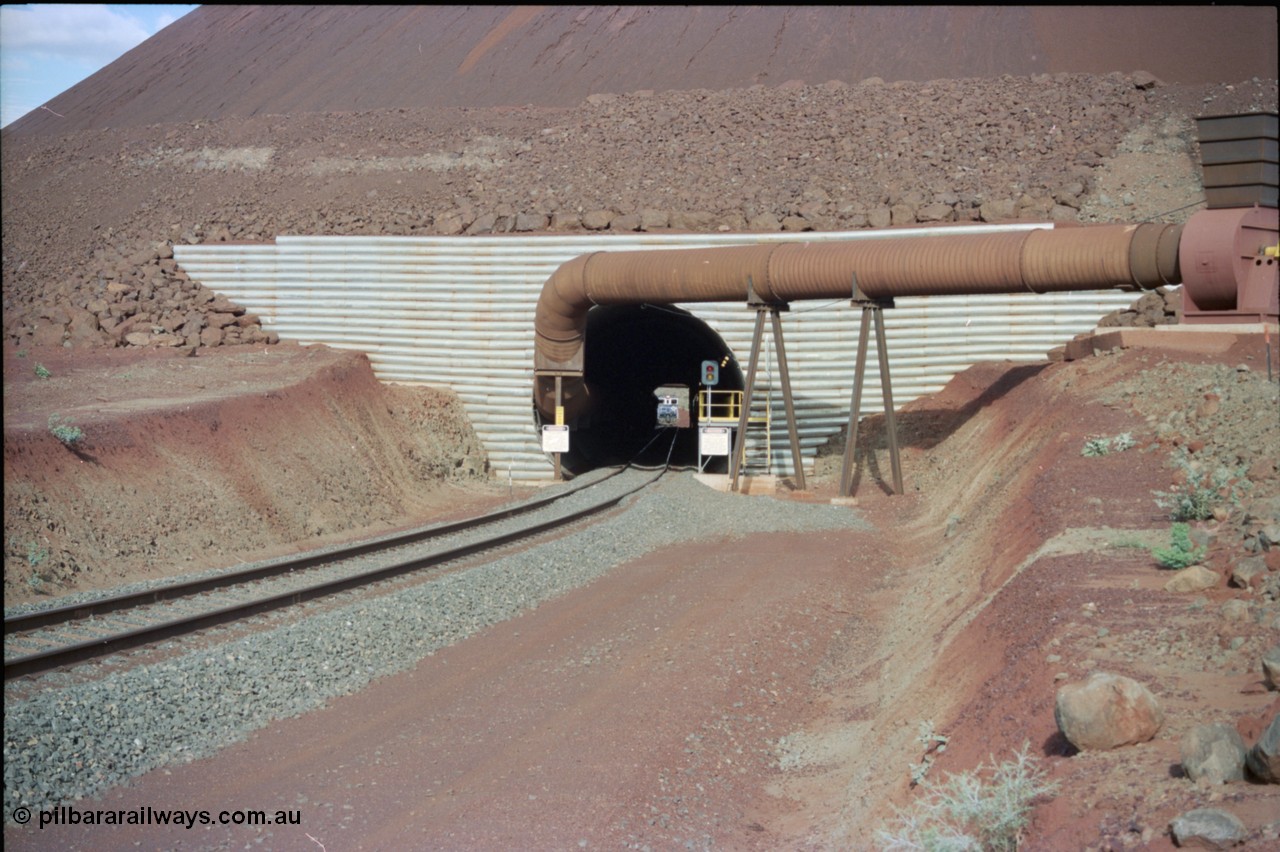 233-02
Yandi Two exit portal or loaded car side of load-out tunnel, the Yandi Two load-out has two load-out stations or vaults to allow to different products to be loaded. Only one vault is used at a time. An empty train can be seen about to enter the tunnel. [url=https://goo.gl/maps/RgJfYGtPXb52]GeoData[/url].
