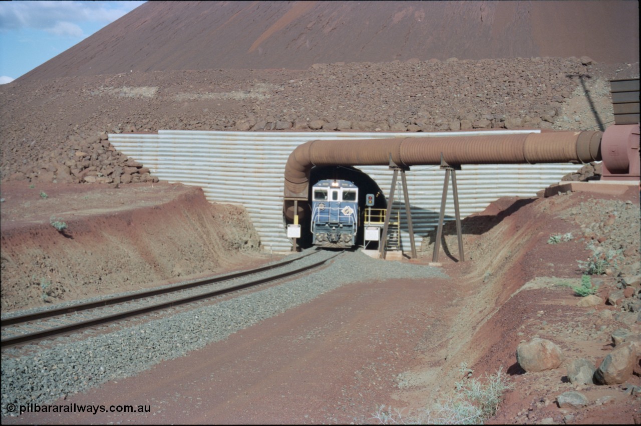 233-08
Yandi Two exit portal or loaded car side of load-out tunnel, the Yandi Two load-out has two load-out stations or vaults to allow to different products to be loaded. Only one vault is used at a time. An empty train lead by BHP Iron Ore's Goninan rebuild CM40-8M GE unit 5650 'Yawata' serial 8412-07 / 93-141 as it drags the train through at 1.2 km/h. [url=https://goo.gl/maps/RgJfYGtPXb52]GeoData[/url].
Keywords: 5650;Goninan;GE;CM40-8M;8412-07/93-141;rebuild;AE-Goodwin;ALCo;M636C;5481;G6061-2;