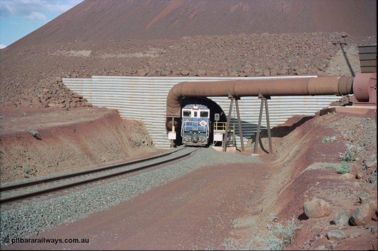 233-09
Yandi Two exit portal or loaded car side of load-out tunnel, the Yandi Two load-out has two load-out stations or vaults to allow to different products to be loaded. Only one vault is used at a time. A loading train lead by BHP Iron Ore's Goninan rebuild CM40-8M GE unit 5650 'Yawata' serial 8412-07 / 93-141 as it drags the train through at 1.2 km/h. [url=https://goo.gl/maps/RgJfYGtPXb52]GeoData[/url].
Keywords: 5650;Goninan;GE;CM40-8M;8412-07/93-141;rebuild;AE-Goodwin;ALCo;M636C;5481;G6061-2;