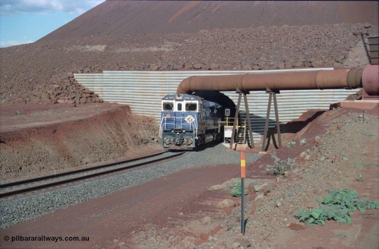 233-11
Yandi Two exit portal or loaded car side of load-out tunnel, the Yandi Two load-out has two load-out stations or vaults to allow to different products to be loaded. Only one vault is used at a time. A loading train lead by BHP Iron Ore's Goninan rebuild CM40-8M GE unit 5650 'Yawata' serial 8412-07 / 93-141 as it drags the train through at 1.2 km/h. [url=https://goo.gl/maps/RgJfYGtPXb52]GeoData[/url].
Keywords: 5650;Goninan;GE;CM40-8M;8412-07/93-141;rebuild;AE-Goodwin;ALCo;M636C;5481;G6061-2;