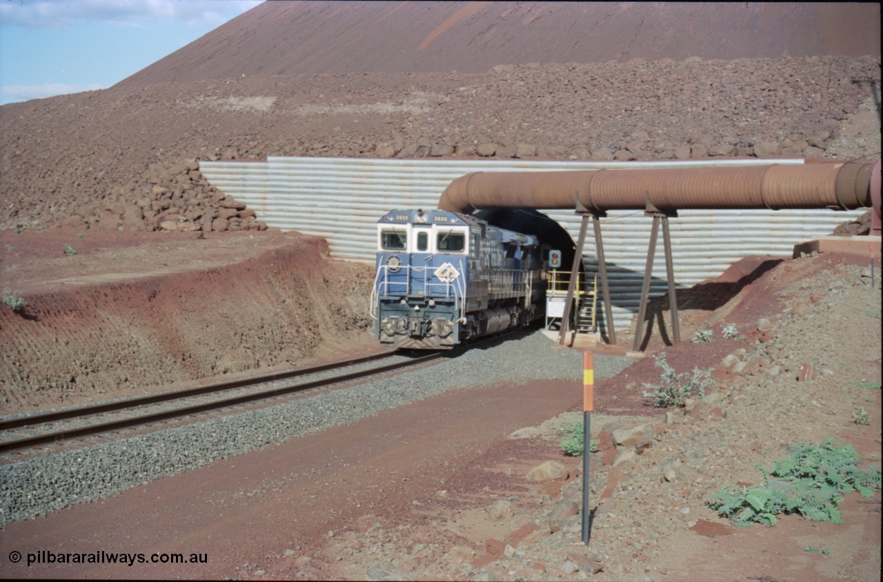 233-12
Yandi Two exit portal or loaded car side of load-out tunnel, the Yandi Two load-out has two load-out stations or vaults to allow to different products to be loaded. Only one vault is used at a time. A loading train lead by BHP Iron Ore's Goninan rebuild CM40-8M GE unit 5650 'Yawata' serial 8412-07 / 93-141 as it drags the train through at 1.2 km/h. [url=https://goo.gl/maps/RgJfYGtPXb52]GeoData[/url].
Keywords: 5650;Goninan;GE;CM40-8M;8412-07/93-141;rebuild;AE-Goodwin;ALCo;M636C;5481;G6061-2;