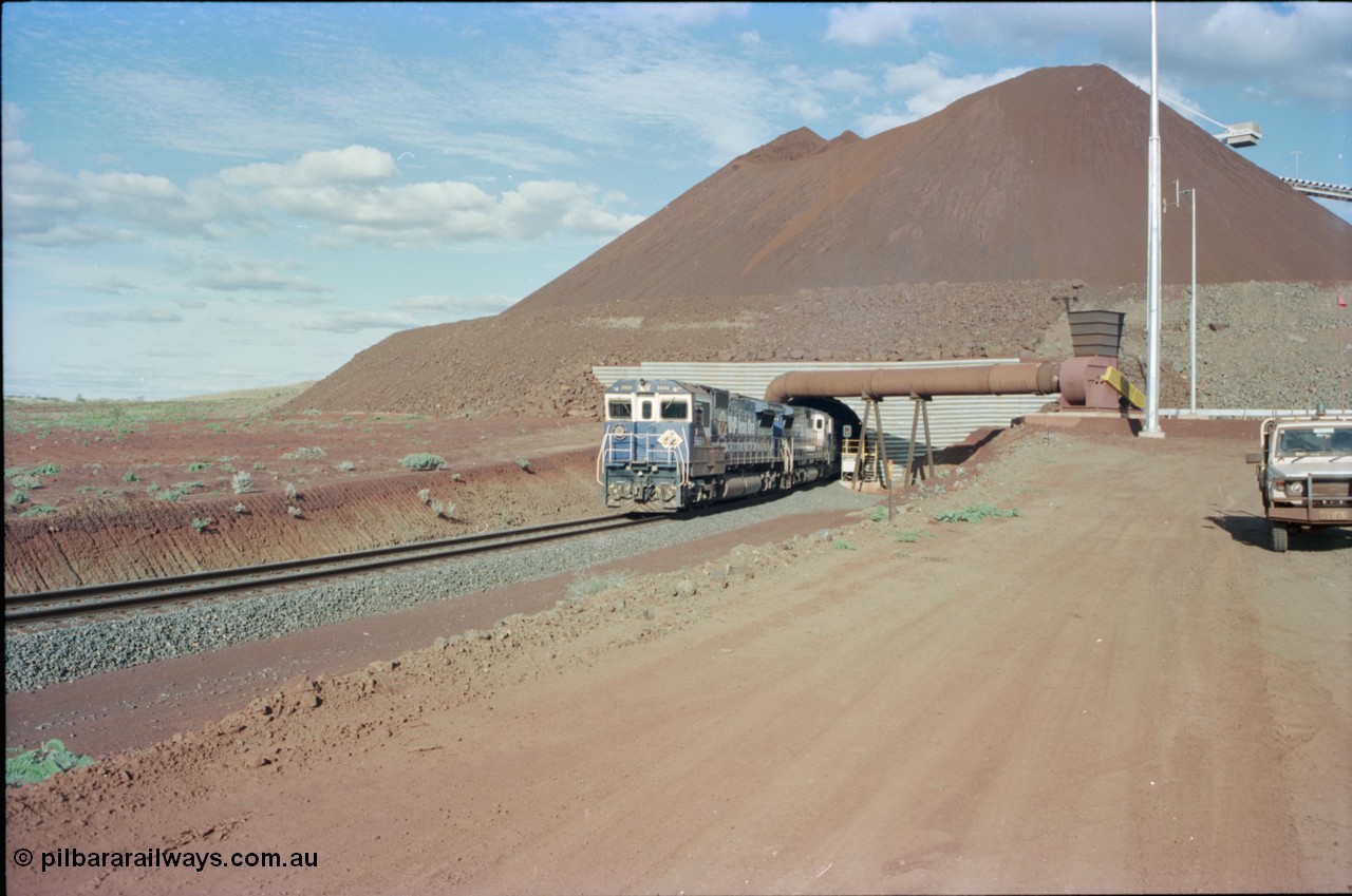 233-14
Yandi Two exit portal or loaded car side of load-out tunnel, the Yandi Two load-out has two load-out stations or vaults to allow to different products to be loaded. Only one vault is used at a time. A loading train lead by BHP Iron Ore's Goninan rebuild CM40-8M GE unit 5650 'Yawata' serial 8412-07 / 93-141 as it drags the train through at 1.2 km/h with assistance from two sister units. [url=https://goo.gl/maps/RgJfYGtPXb52]GeoData[/url].
Keywords: 5650;Goninan;GE;CM40-8M;8412-07/93-141;rebuild;AE-Goodwin;ALCo;M636C;5481;G6061-2;