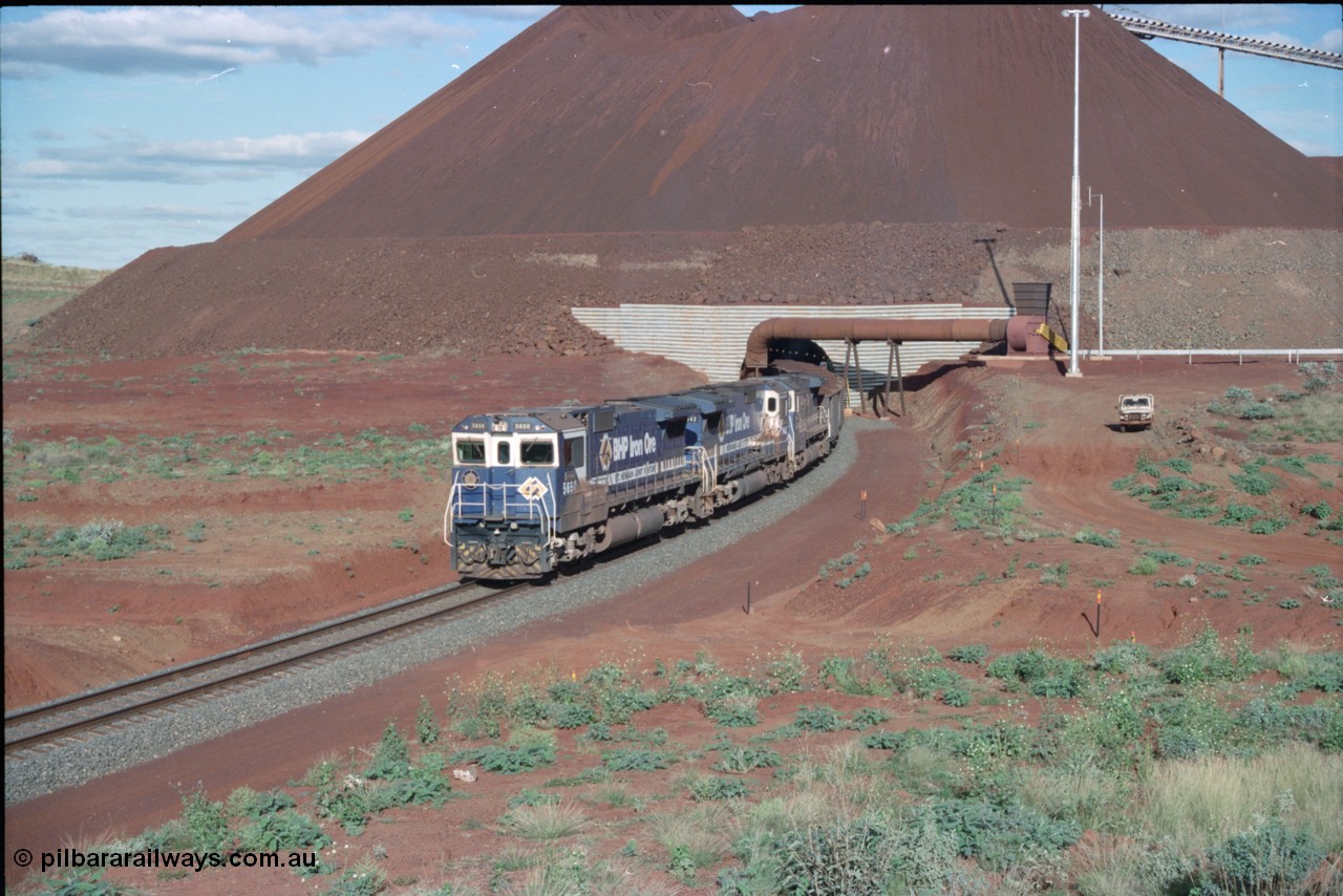 233-21
Yandi Two exit portal or loaded car side of load-out tunnel, the Yandi Two load-out has two load-out stations or vaults to allow to different products to be loaded. Only one vault is used at a time. A loading train lead by BHP Iron Ore's Goninan rebuild CM40-8M GE unit 5650 'Yawata' serial 8412-07 / 93-141 as it drags the train through at 1.2 km/h with assistance from two sister units. [url=https://goo.gl/maps/gXRbfYH9U482]GeoData[/url].
Keywords: 5650;Goninan;GE;CM40-8M;8412-07/93-141;rebuild;AE-Goodwin;ALCo;M636C;5481;G6061-2;