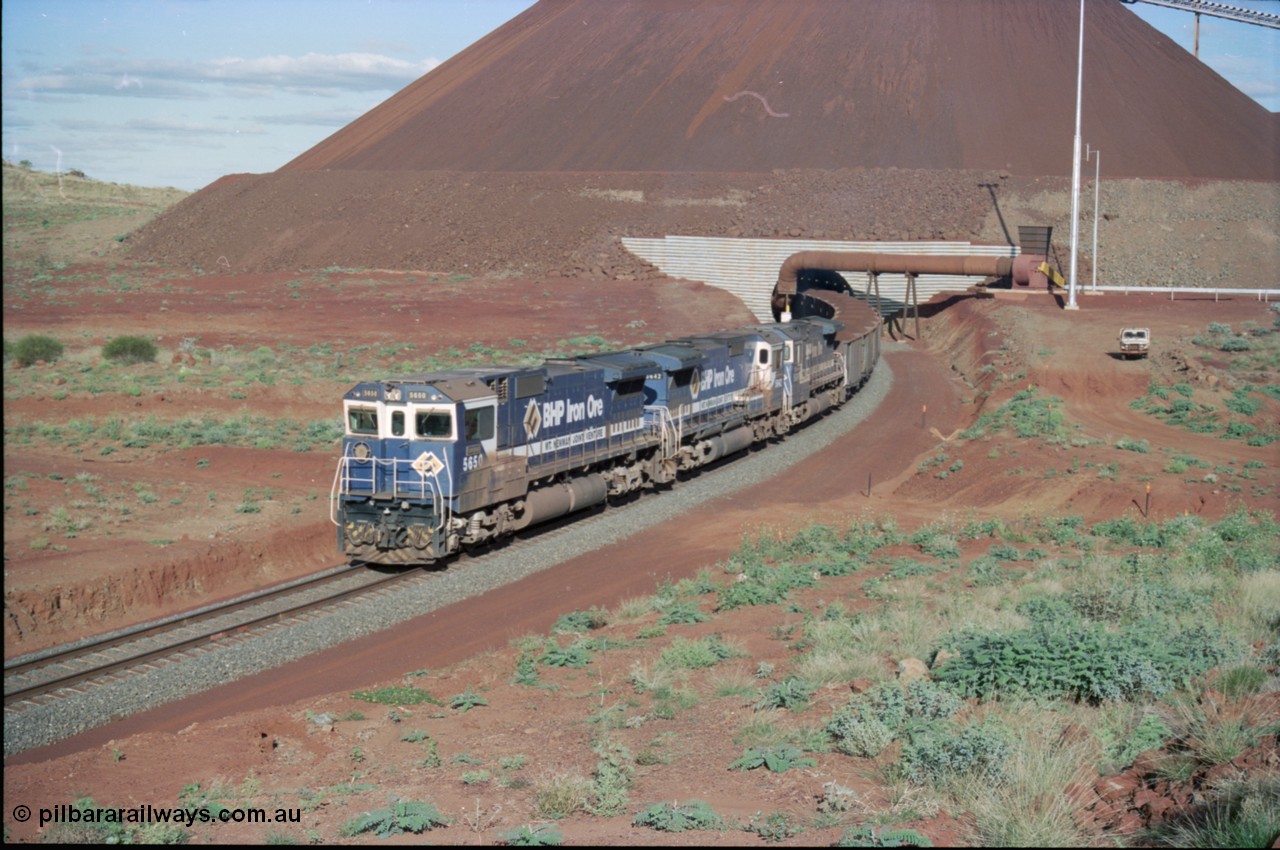 233-24
Yandi Two exit portal or loaded car side of load-out tunnel, the Yandi Two load-out has two load-out stations or vaults to allow to different products to be loaded. Only one vault is used at a time. A loading train lead by BHP Iron Ore's Goninan rebuild CM40-8M GE unit 5650 'Yawata' serial 8412-07 / 93-141 as it drags the train through at 1.2 km/h with assistance from two sister units. [url=https://goo.gl/maps/gXRbfYH9U482]GeoData[/url].
Keywords: 5650;Goninan;GE;CM40-8M;8412-07/93-141;rebuild;AE-Goodwin;ALCo;M636C;5481;G6061-2;