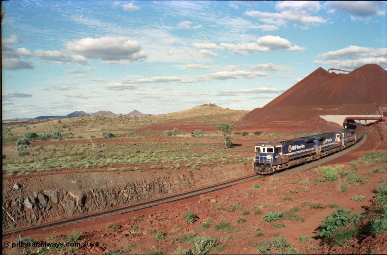 233-26
Yandi Two loaded car side of load-out tunnel, a loading train lead by BHP Iron Ore's Goninan rebuild CM40-8M GE unit 5650 'Yawata' serial 8412-07 / 93-141 as it drags the train around at 1.2 km/h with assistance from two sister units, the end of the 112 waggon or one rake consist can be seen in the middle background. [url=https://goo.gl/maps/gXRbfYH9U482]GeoData[/url].
Keywords: 5650;Goninan;GE;CM40-8M;8412-07/93-141;rebuild;AE-Goodwin;ALCo;M636C;5481;G6061-2;