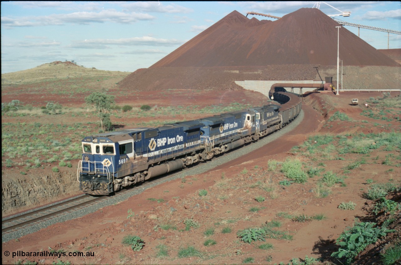 233-28
Yandi Two loaded car side of load-out tunnel, a loading train lead by BHP Iron Ore's Goninan rebuild CM40-8M GE unit 5650 'Yawata' serial 8412-07 / 93-141 as it drags the train through at 1.2 km/h with assistance from two sister units. [url=https://goo.gl/maps/gXRbfYH9U482]GeoData[/url].
Keywords: 5650;Goninan;GE;CM40-8M;8412-07/93-141;rebuild;AE-Goodwin;ALCo;M636C;5481;G6061-2;