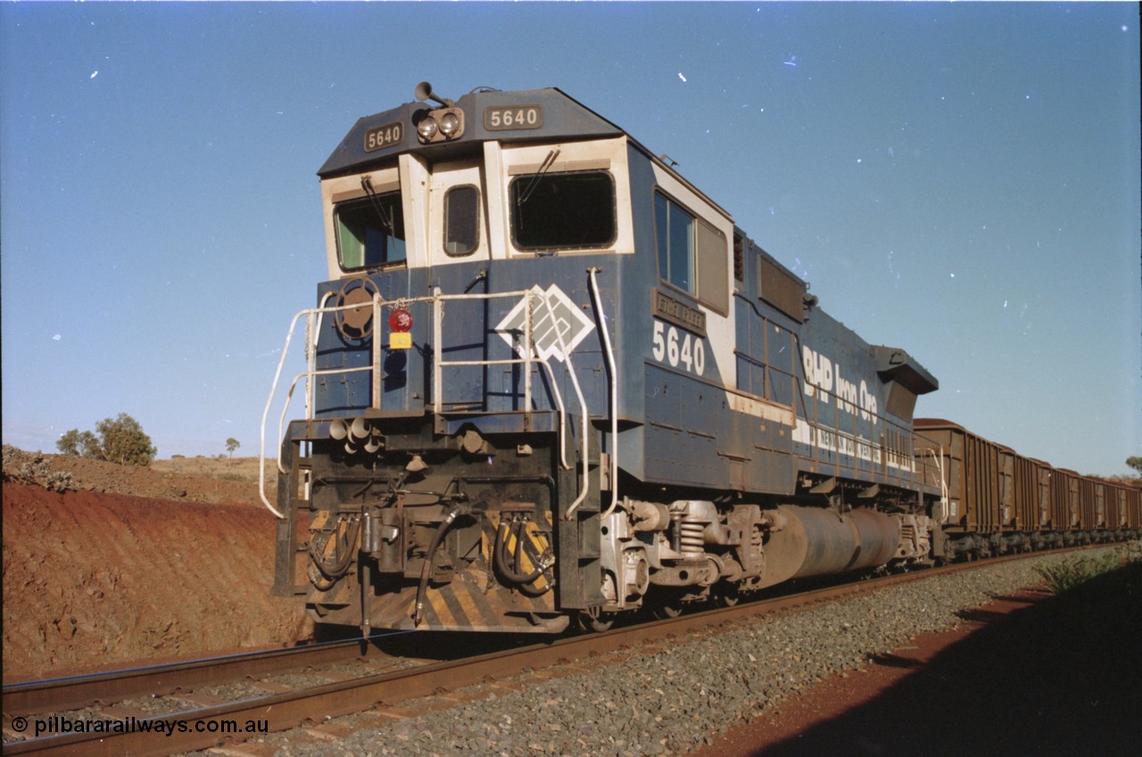 234-02
Yandi Two, BHP Iron Ore Goninan rebuild CM40-8M GE unit 5640 'Ethel Creek' serial 8281-05 / 92-129 is on the rear of a 240 waggon loaded train, this configuration was trialled for a time with two Dash 8 locos, 120 waggons, Dash 8, 120 waggons and Dash 8. As this series of rebuilds has no marker lights not the red lantern attached to the hand rail. Circa 1998.
Keywords: 5640;Goninan;GE;CM40-8M;8281-05/92-129;rebuild;AE-Goodwin;ALCo;M636C;5479;G6047-11;