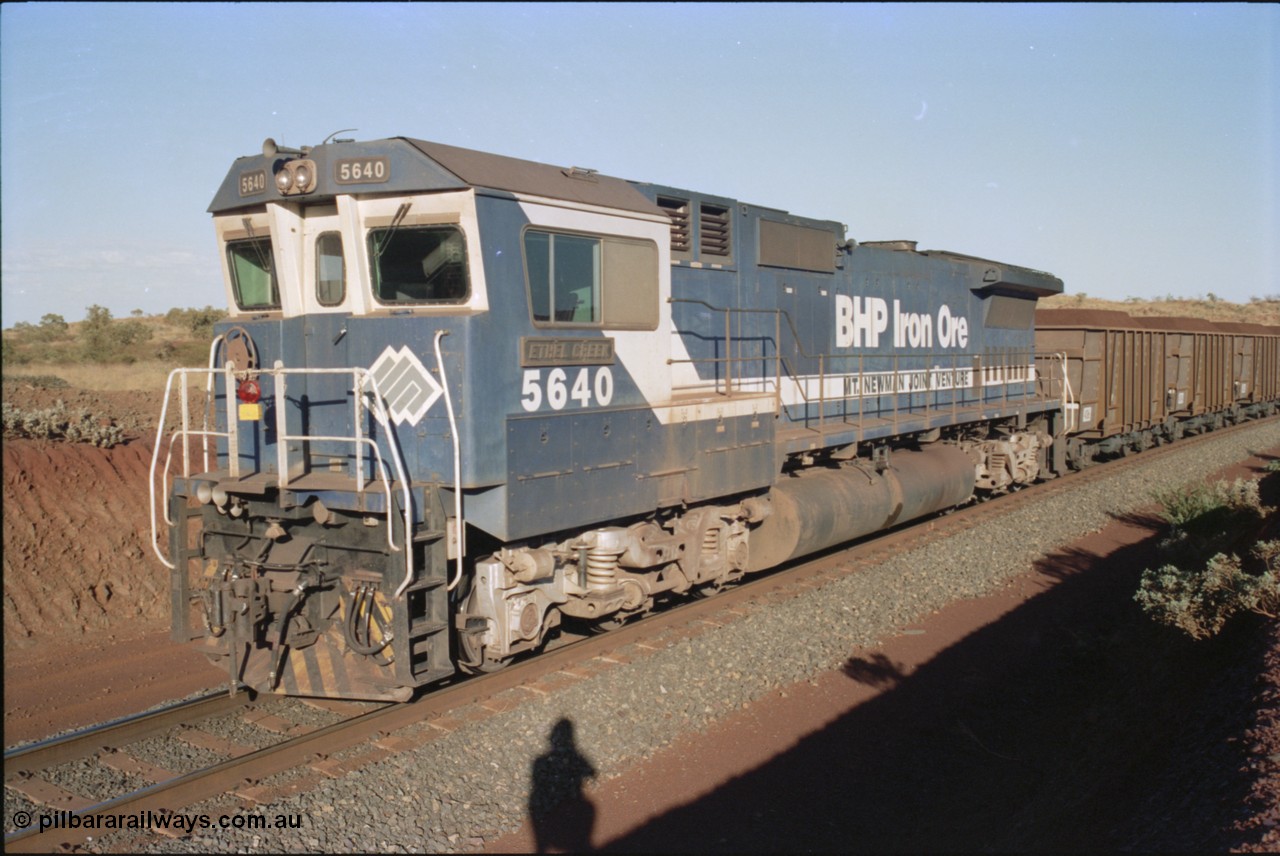 234-07
Yandi Two, BHP Iron Ore Goninan rebuild CM40-8M GE unit 5640 'Ethel Creek' serial 8281-05 / 92-129 is on the rear of a 240 waggon loaded train, this configuration was trialled for a time with two Dash 8 locos, 120 waggons, Dash 8, 120 waggons and Dash 8. As this series of rebuilds has no marker lights not the red lantern attached to the hand rail. Circa 1998.
Keywords: 5640;Goninan;GE;CM40-8M;8281-05/92-129;rebuild;AE-Goodwin;ALCo;M636C;5479;G6047-11;