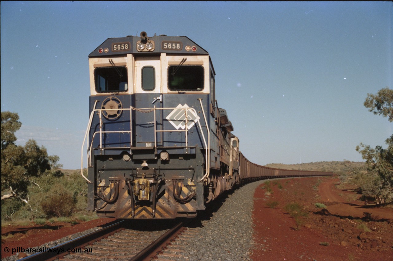 234-19
Yandi Two, BHP Iron Ore Goninan rebuild CM40-8M GE unit 5658 'Kakogawa' serial 8412-03 / 94-149 on the front of a 240 waggon loaded train, this configuration was trialled for a time with two Dash 8 locos, 120 waggons, Dash 8, 120 waggons and Dash 8. Circa 1998.
Keywords: 5658;Goninan;GE;CM40-8M;8412-03/94-149;rebuild;AE-Goodwin;ALCo;M636C;5480;G6061-1;