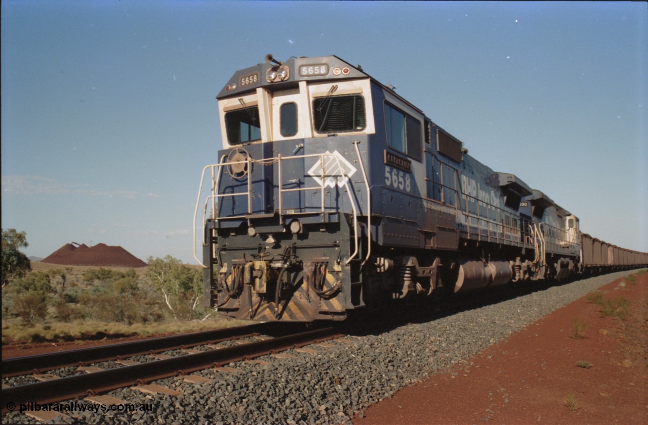 234-27
Yandi Two, BHP Iron Ore Goninan rebuild CM40-8M GE unit 5658 'Kakogawa' serial 8412-03 / 94-149 on the front of a 240 waggon loaded train, this configuration was trialled for a time with two Dash 8 locos, 120 waggons, Dash 8, 120 waggons and Dash 8. Cab front on view. Circa 1998.
Keywords: 5658;Goninan;GE;CM40-8M;8412-03/94-149;rebuild;AE-Goodwin;ALCo;M636C;5480;G6061-1;
