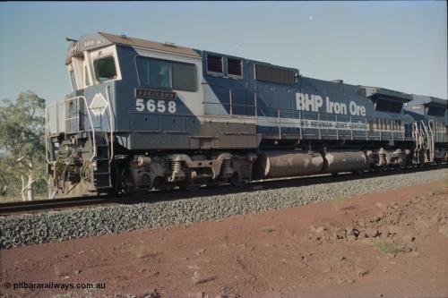 234-21
Yandi Two, BHP Iron Ore Goninan rebuild CM40-8M GE unit 5658 'Kakogawa' serial 8412-03 / 94-149 on the front of a 240 waggon loaded train, this configuration was trialled for a time with two Dash 8 locos, 120 waggons, Dash 8, 120 waggons and Dash 8. Cab front on view. Circa 1998.
Keywords: 5658;Goninan;GE;CM40-8M;8412-03/94-149;rebuild;AE-Goodwin;ALCo;M636C;5480;G6061-1;